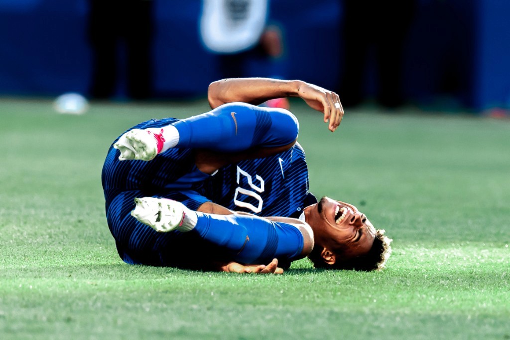 A France player grimaces in pain on the pitch clutching his leg during the World Cup Round of 16 against Paraguay