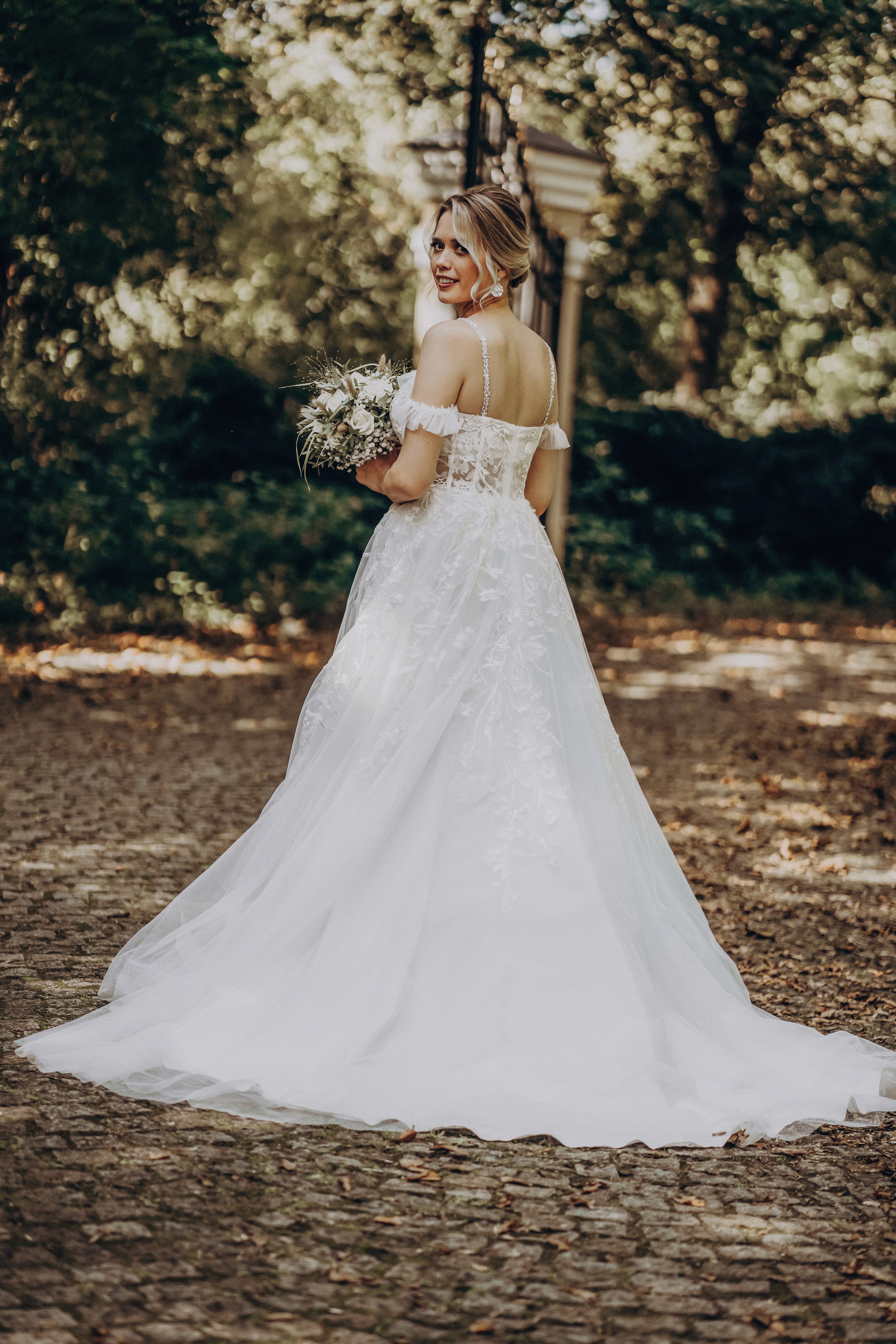 Detailaufnahme der Hochzeitsringe auf dem Bogenberg – Fokus auf Ringe und Brautstrauß