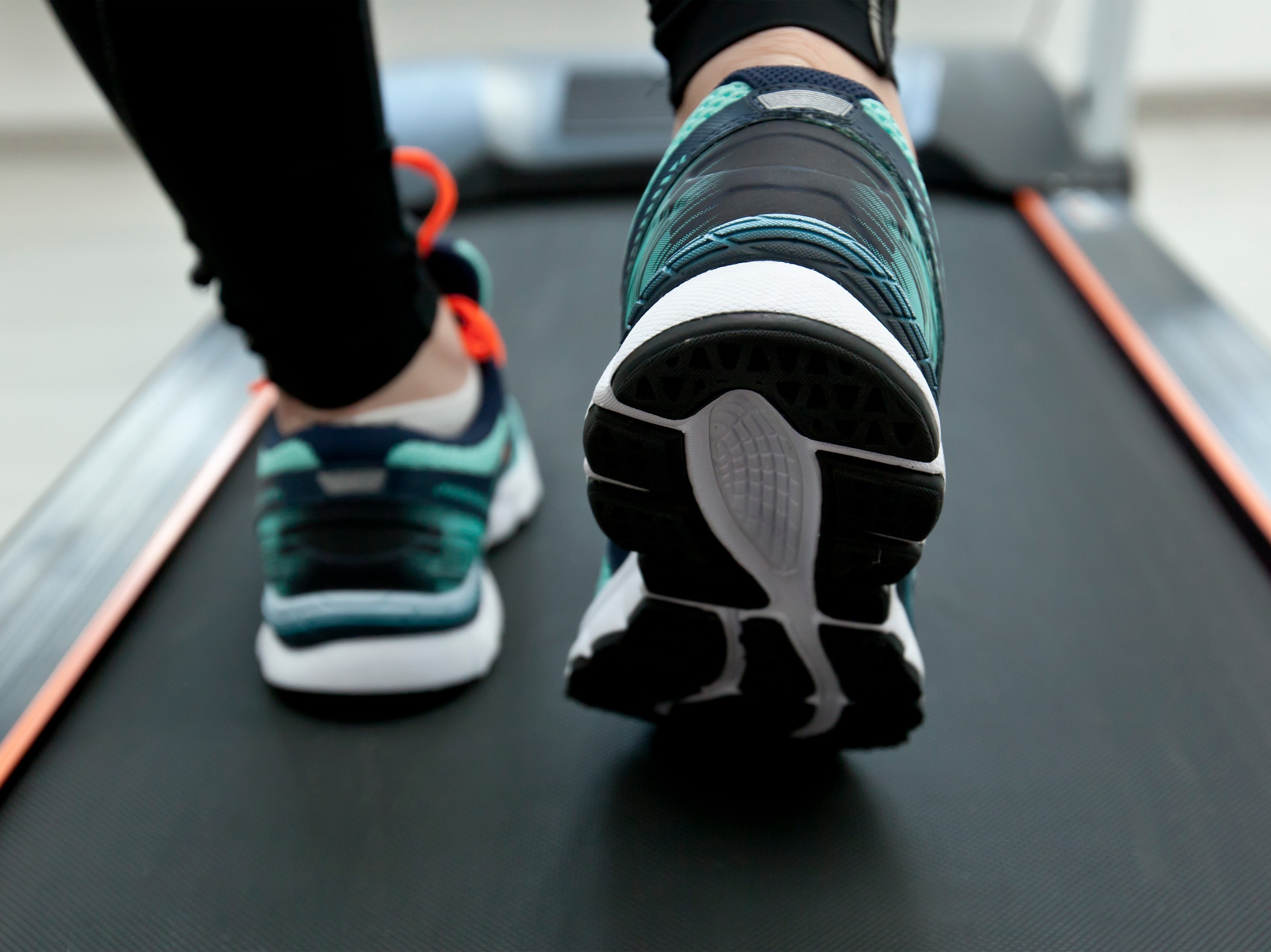 feet of a person at the gym doing an easy walking treadmill workout plan for weight loss on a flat incline