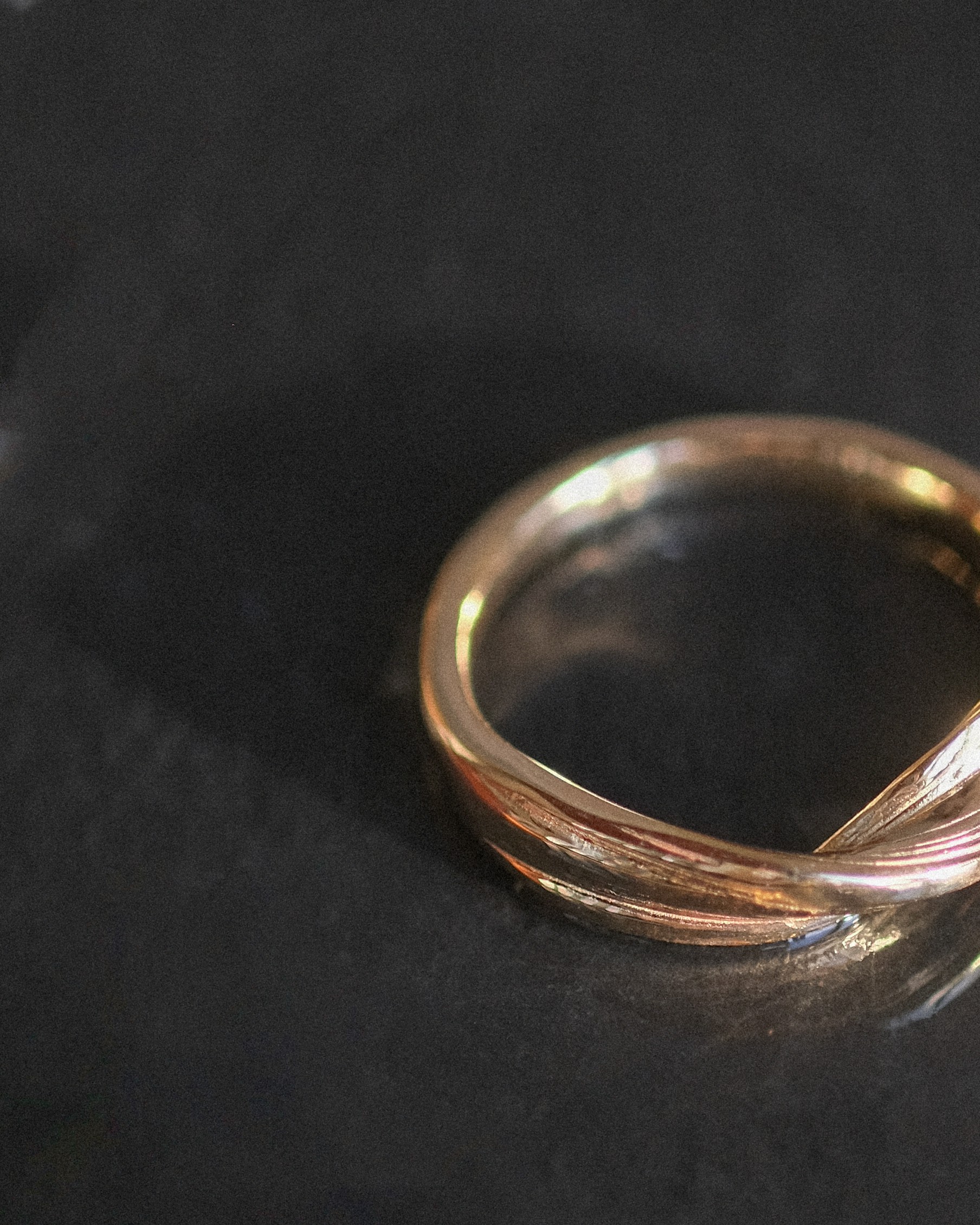 Twisting ring resting on a dark background