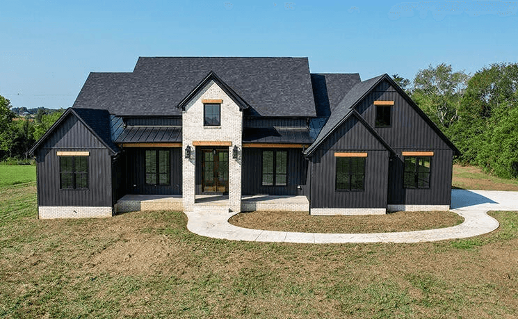 Modern indoor space with large glass doors, lush greenery, and a cozy seating area visible beyond.