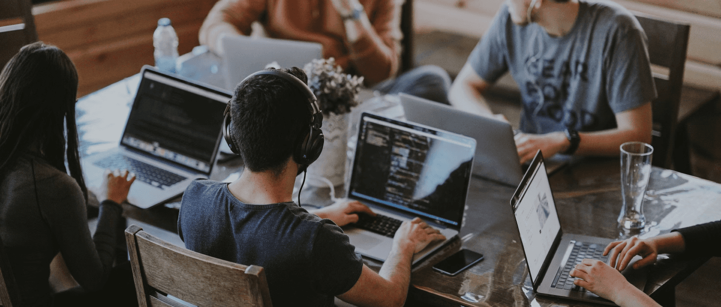 A group of professionals working on laptops in a modern office, showing teamwork for a blog focused on empowering startups.