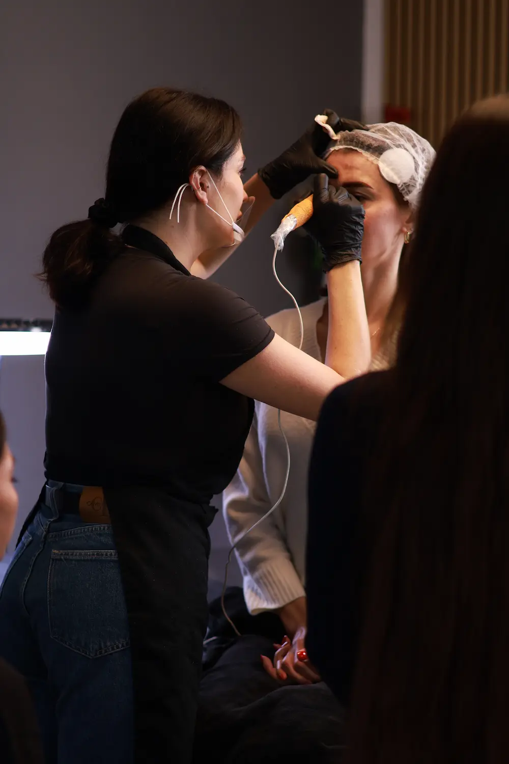 Artist working on client's eyebrow permanent makeup