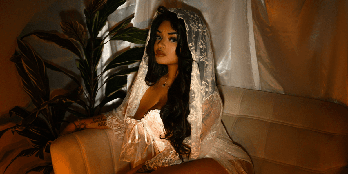 "Anastasia Artemiou seated in a soft, mystical setting, representing her spiritual brand The Manifestation Doll focused on magick, healing, and mindset work."