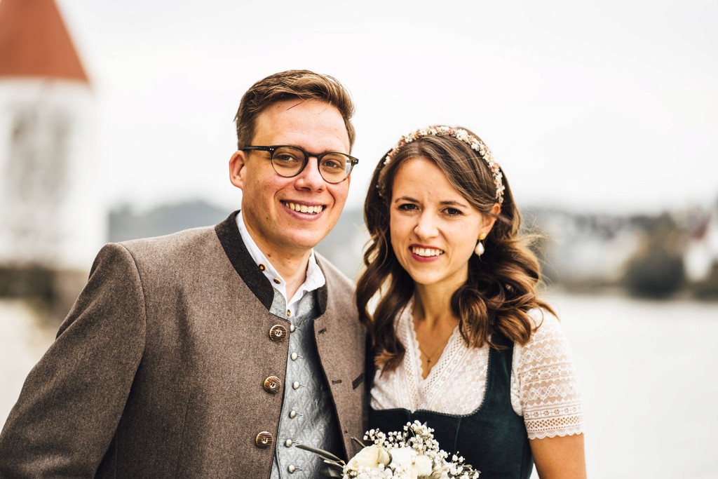 Brautpaar in bayerischer Tracht vor Fluss und Altstadt bei Hochzeit in Passau