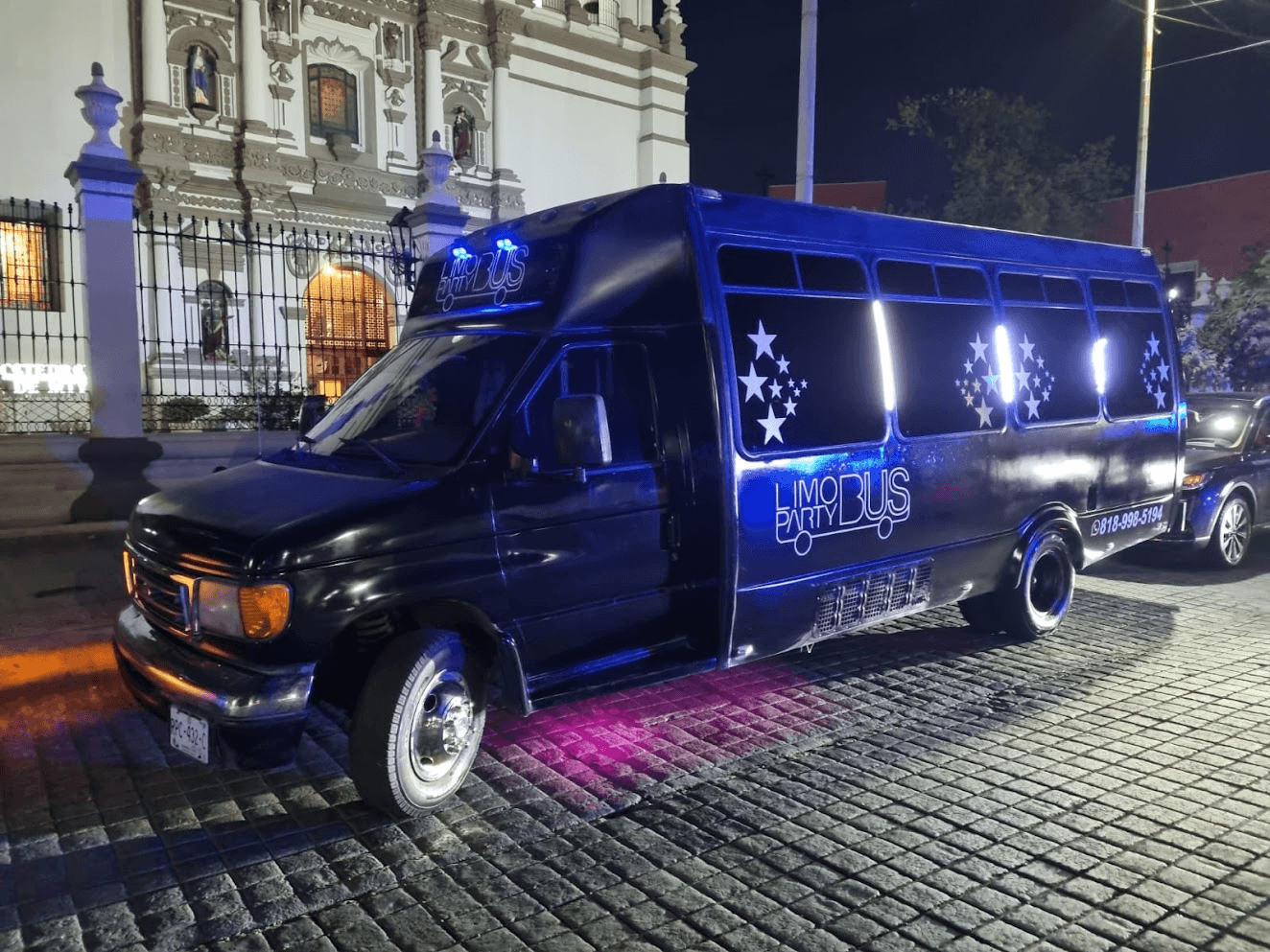 Limo Party Bus negro en Monterrey de noche estacionado para evento de quinceaños