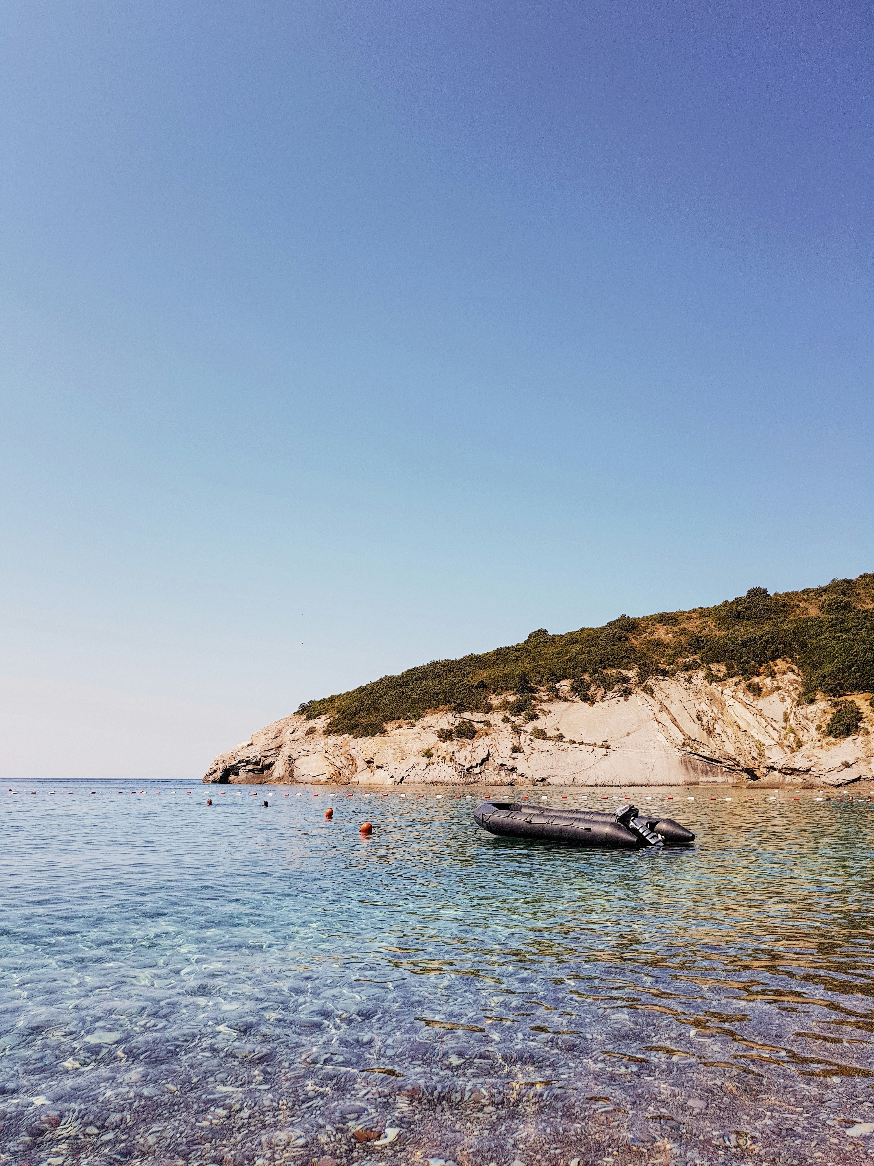 boat on water near mountain during daytime
