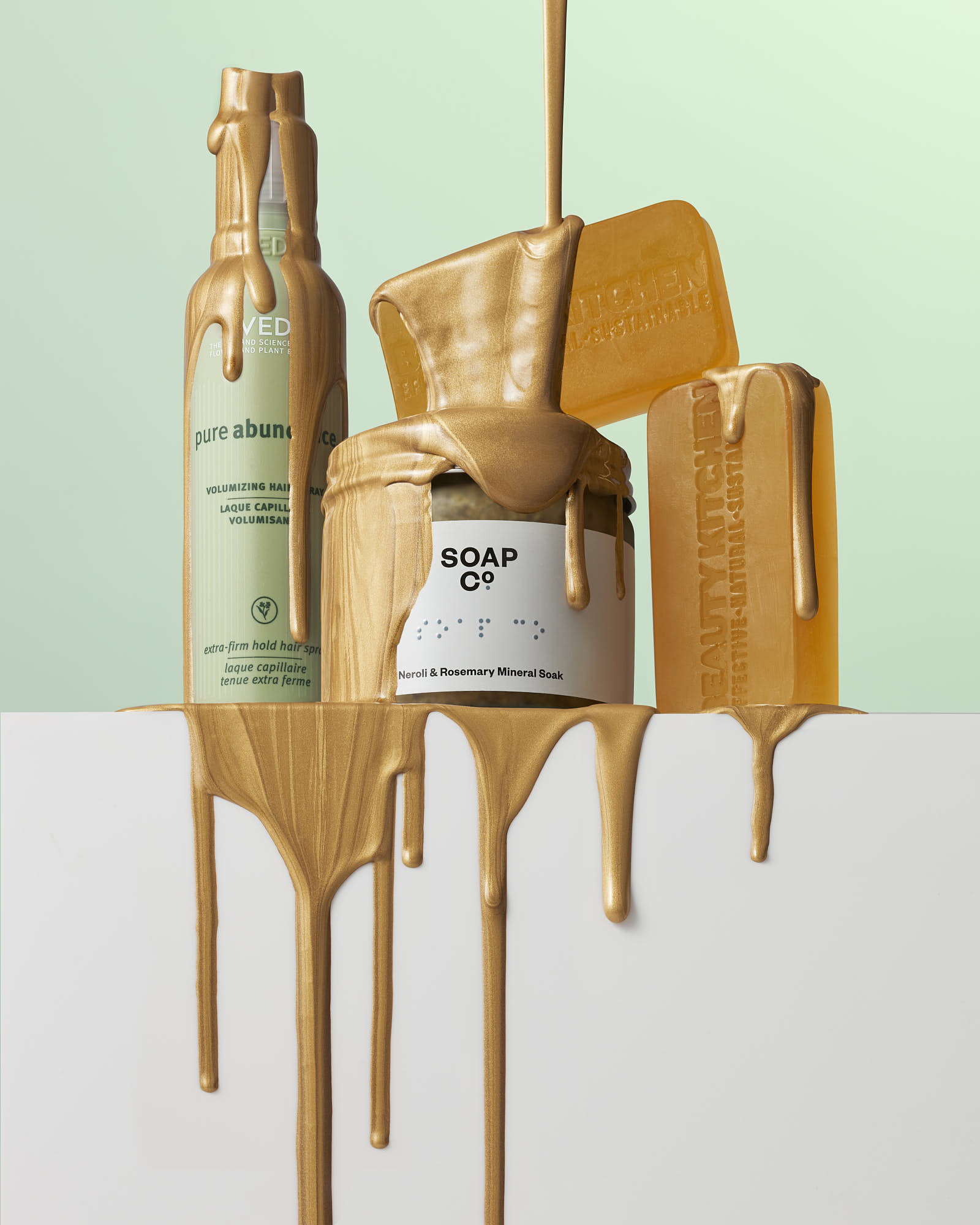 A collection of bottles and jars, partially covered in dripping orange paint, against a pastel background.