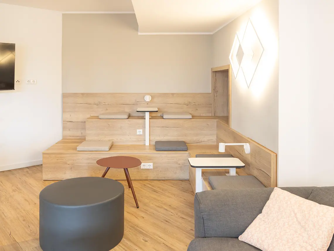 Communal study lounge in student accommodation in Münster with tiered seating, tables and soft furnishings