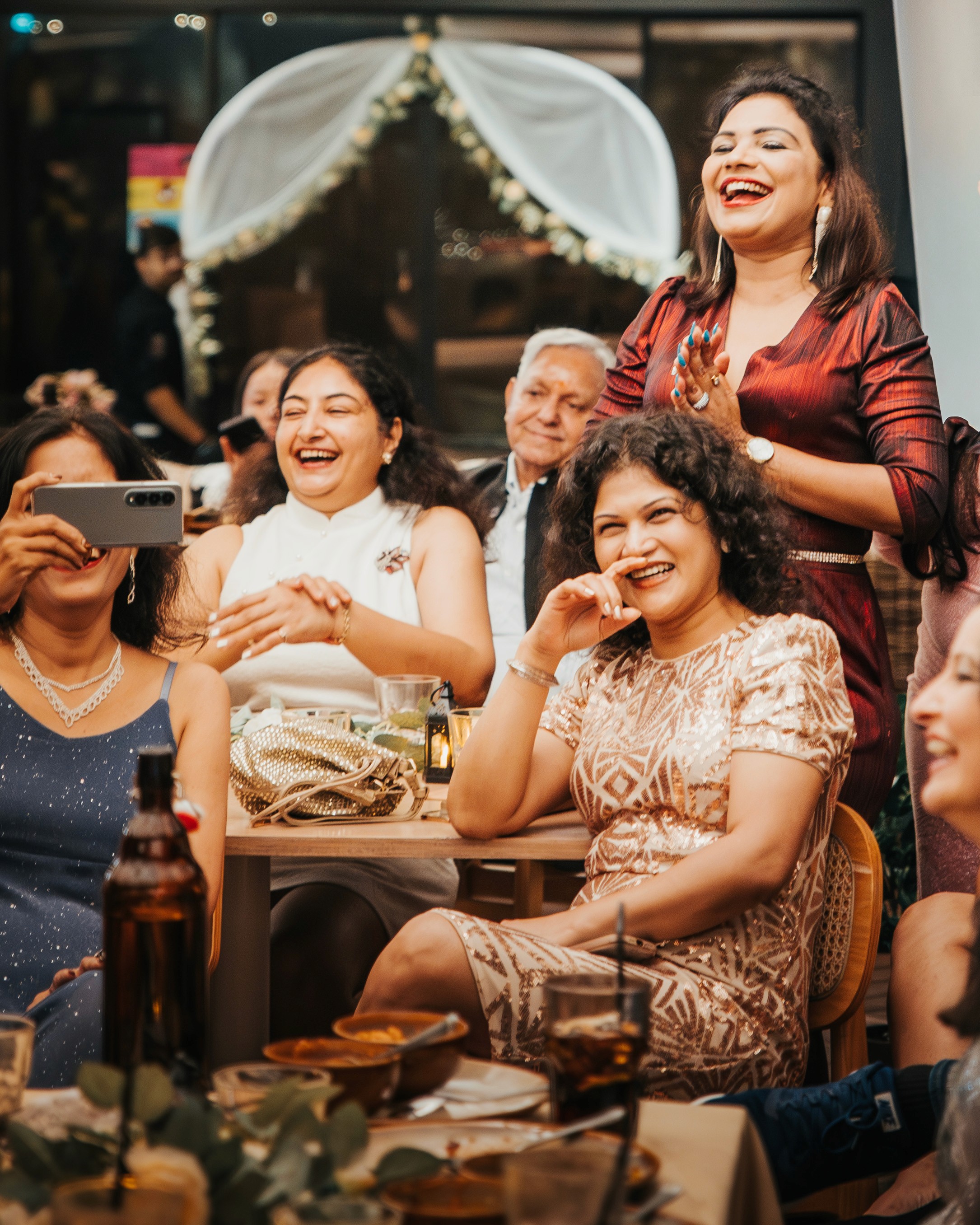 Close-up of guests applauding while seated at their tables in the restaurant.