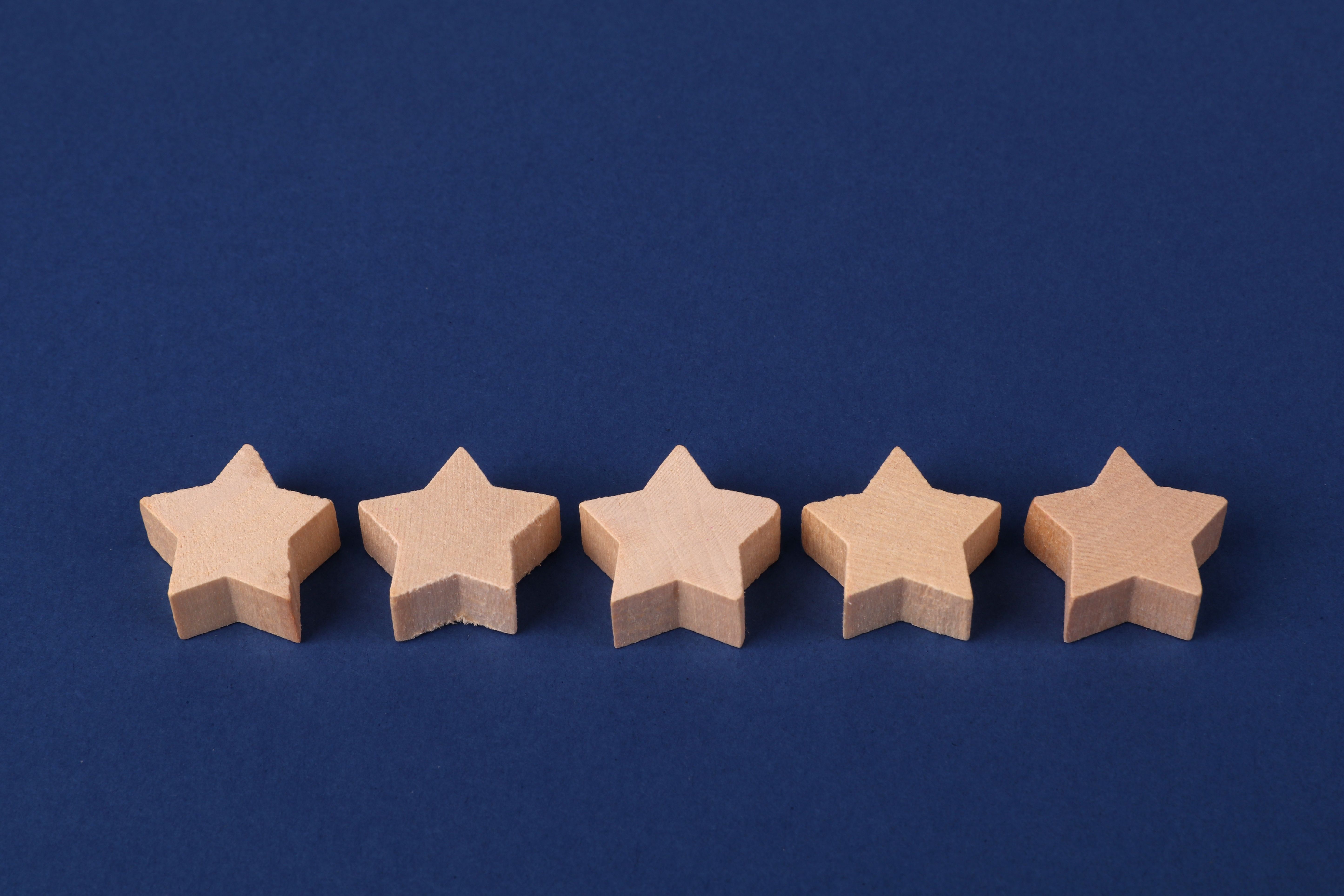 five-wooden-stars-on-a-blue-background-representing-a-rating-system-or-evaluatio - ann-h (pexels)