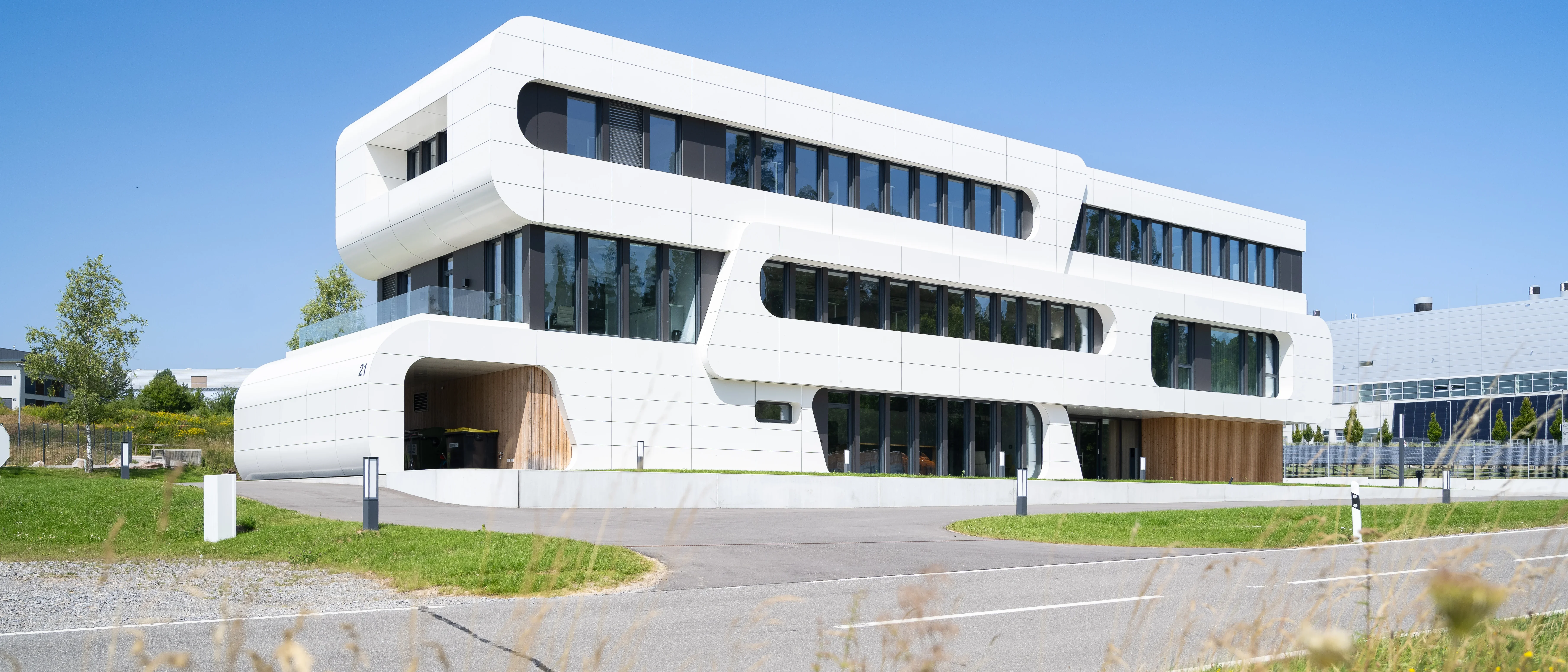 Modernes, zweistöckiges, weißes Bürogebäude mit Glasfenstern