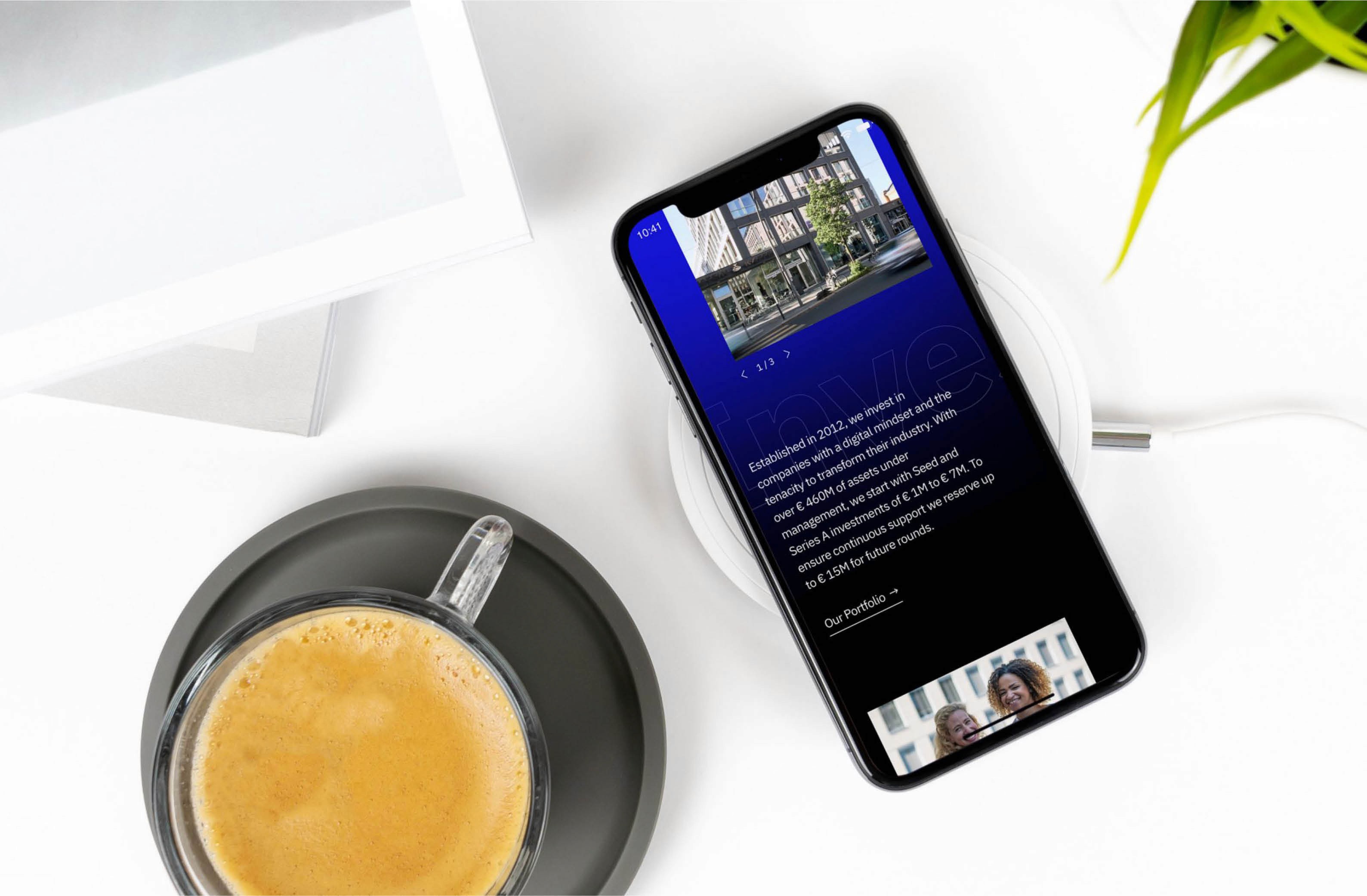 Mobile phone mockup displaying a preview of the Project A website with a dynamic layout, featuring black and blue colors and corporate photos.