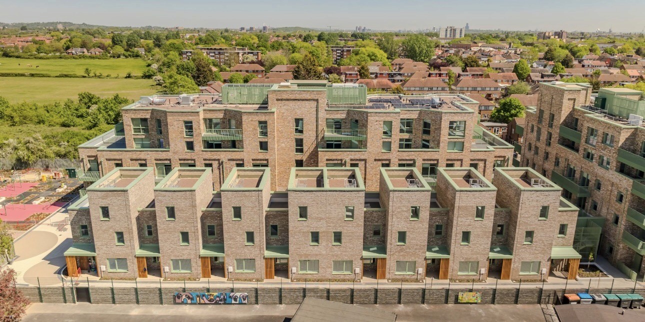 Aerial view of a brick residential development with green metal roof details