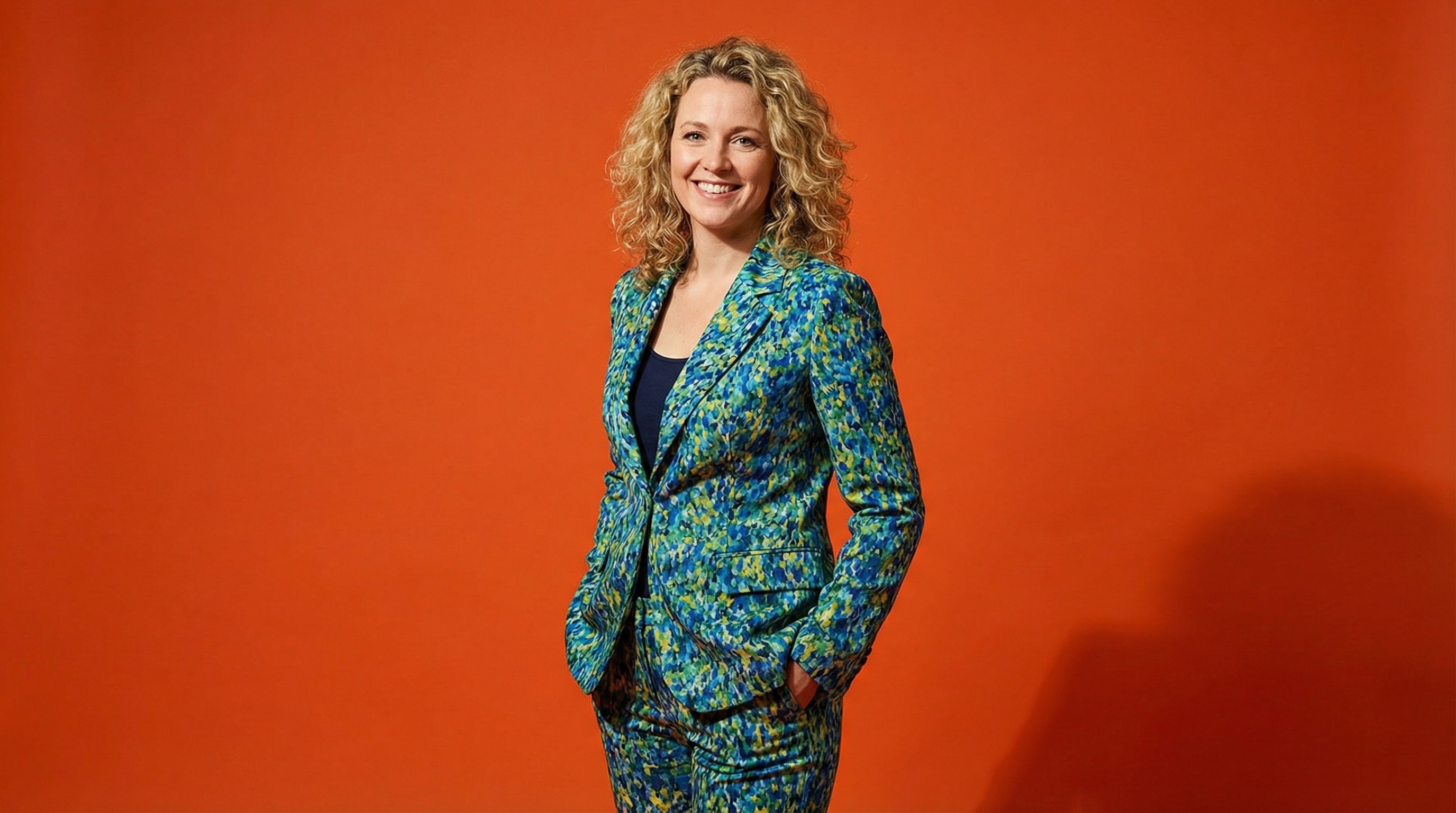 Close-up of lush, dark green leaves, some glossy and wet, against a muted background.