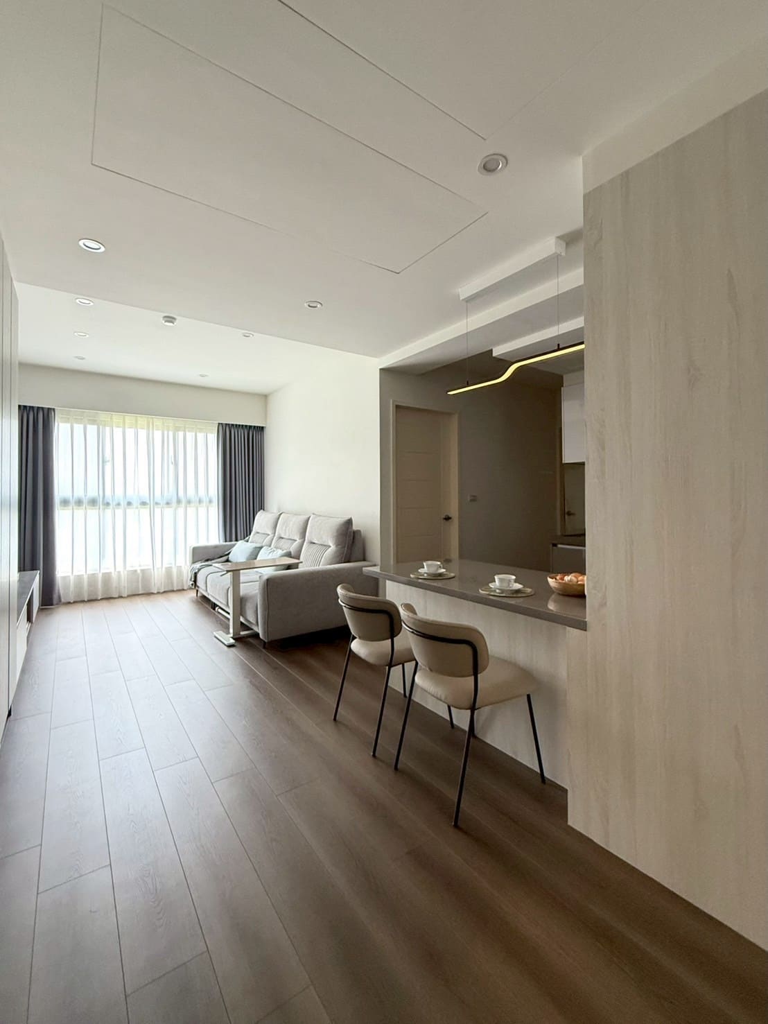 屋研所輕裝修｜客廳結合中島吧台設計，深木質地板與灰色系簡約風格客變空間