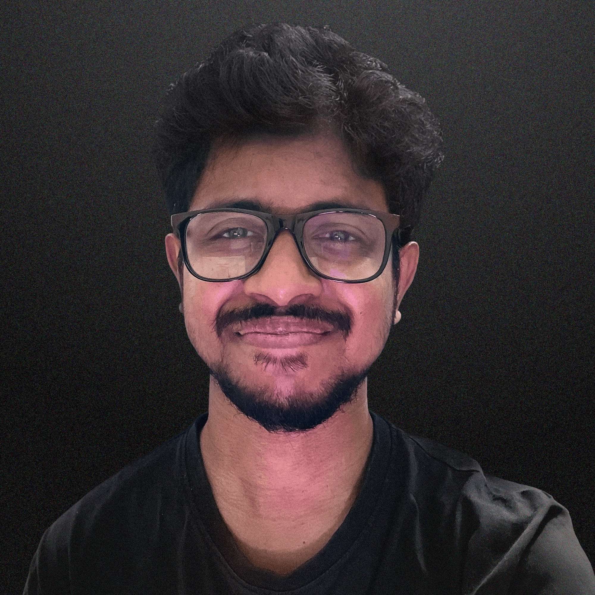 Artistic portrait of a man wearing glasses, illuminated by a diagonal streak of light against a gray background.