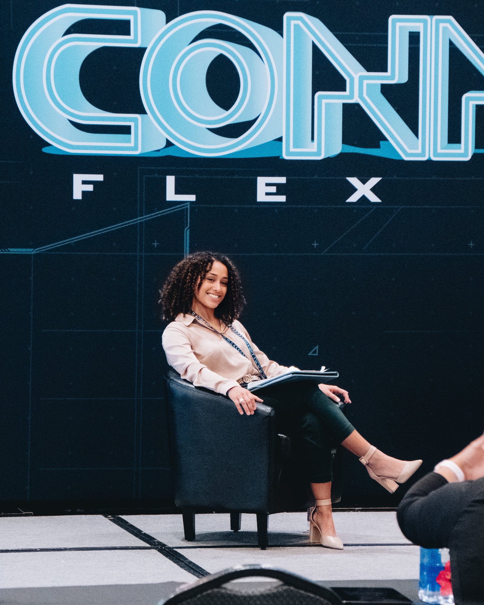 Vanessa seated on stage at Flex Space Connect