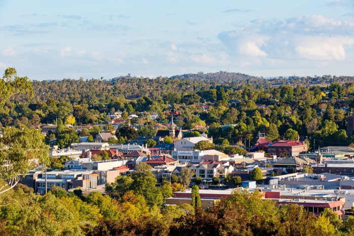 Distant aerial view of a town nestled among green hills.