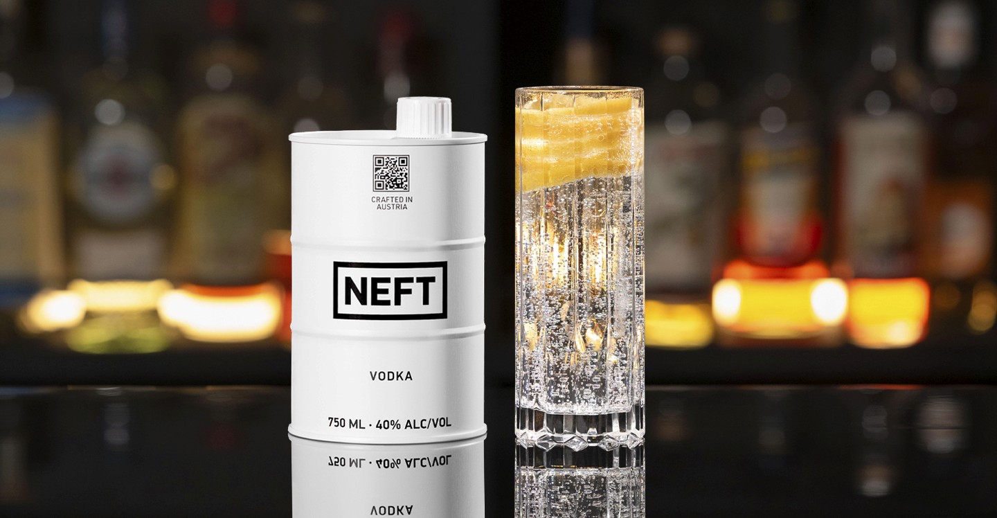 A NEFT Barrel and a glass of The Neon Strip on a bar counter.