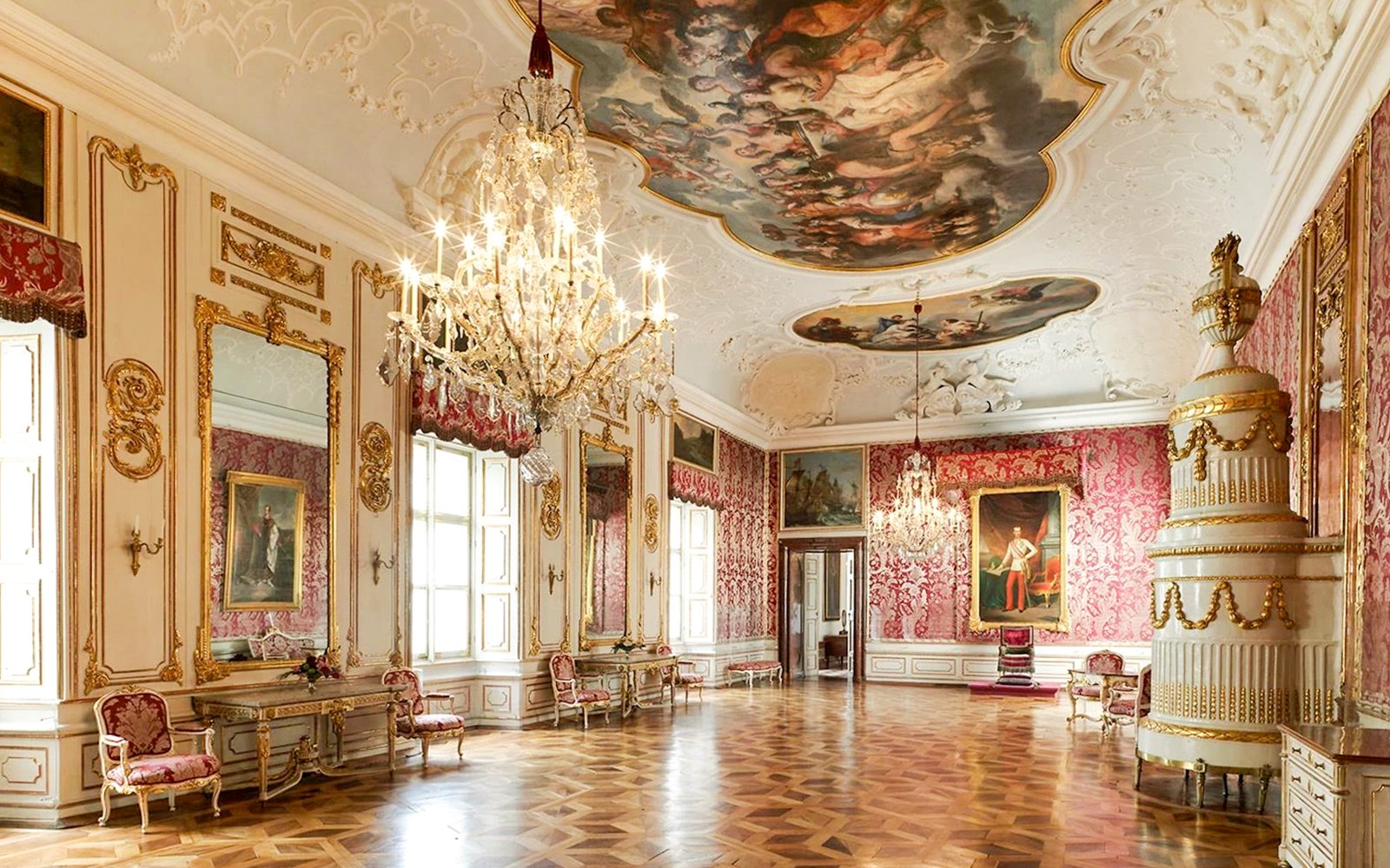 Elegant room in Salzburg's Mirabell Palace with chandeliers and ornate decor.