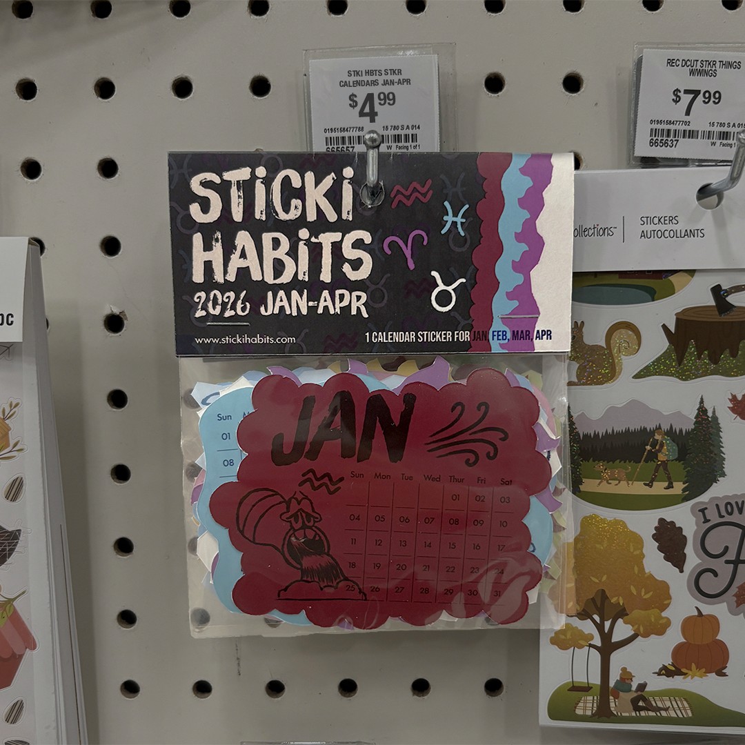 The image shows "Sticki Habits" 2026 calendar stickers for January to April priced at $4.99, hanging in a store display. The design includes colorful, decorative motifs with zodiac symbols.