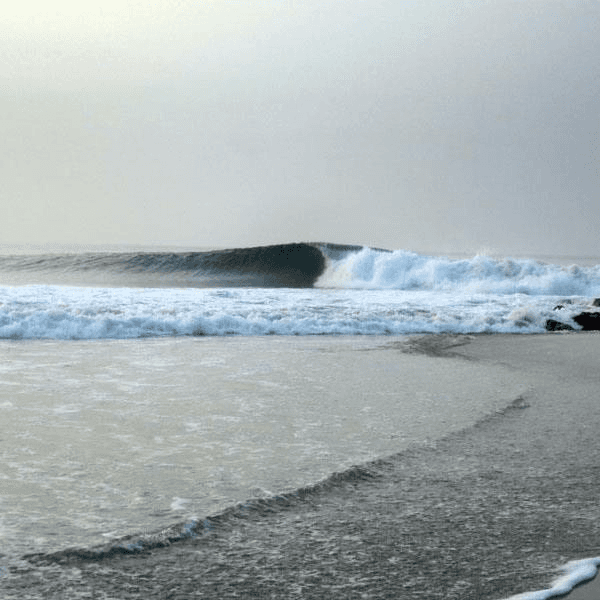Large wave crashing on a sandy beach – surfboard rental in salina-cruz
