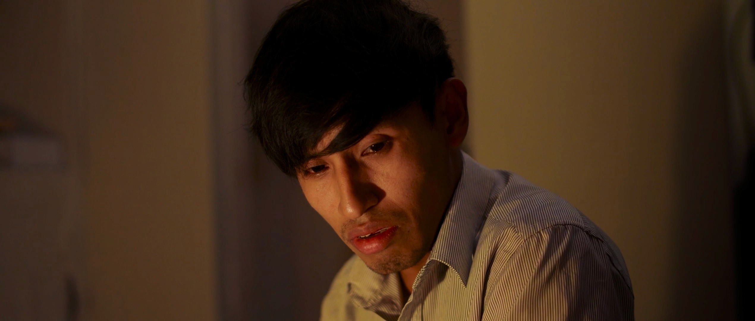 View of the French countryside through a stone villa’s open living room, with sofas and trees framing the scene