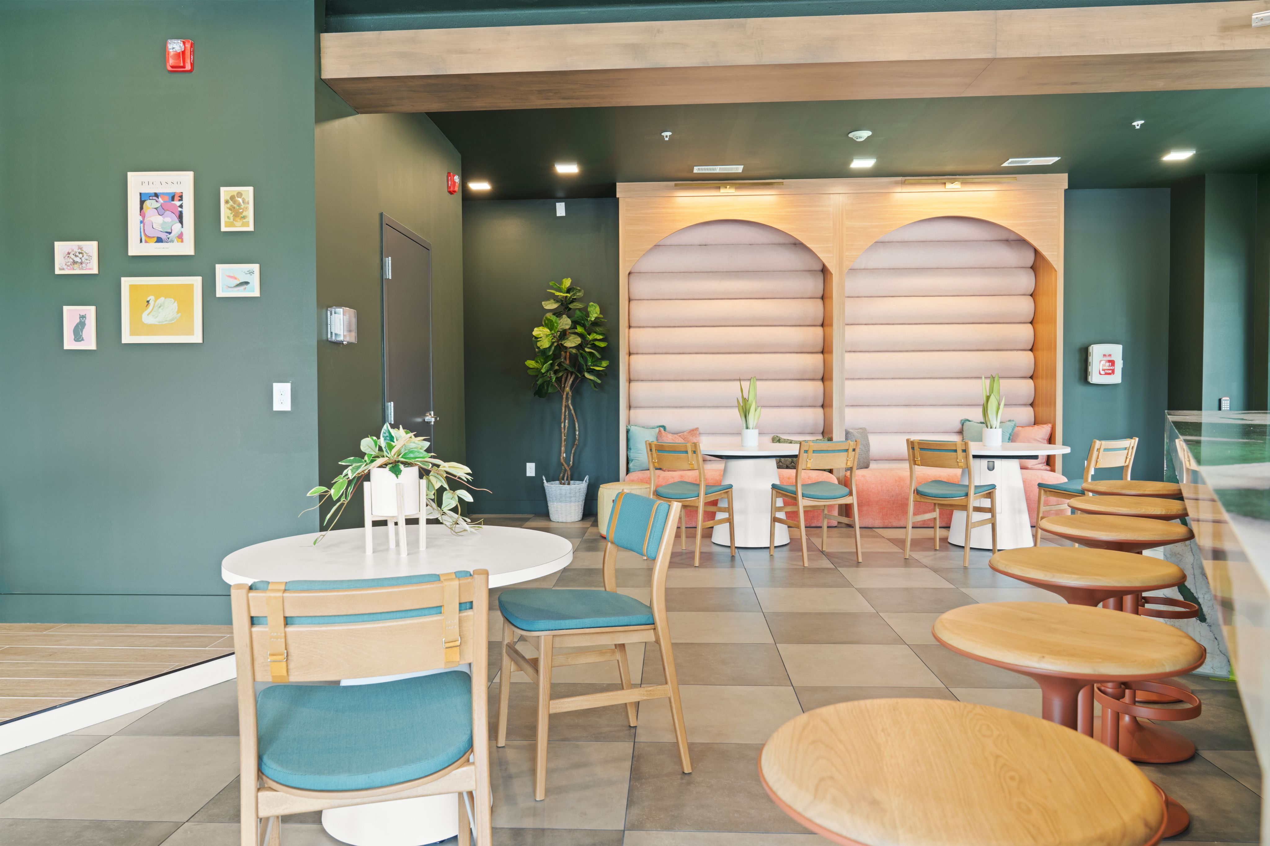 Creative Living Hub interior with green walls and blue chairs, offering a lively and inviting space for diners.