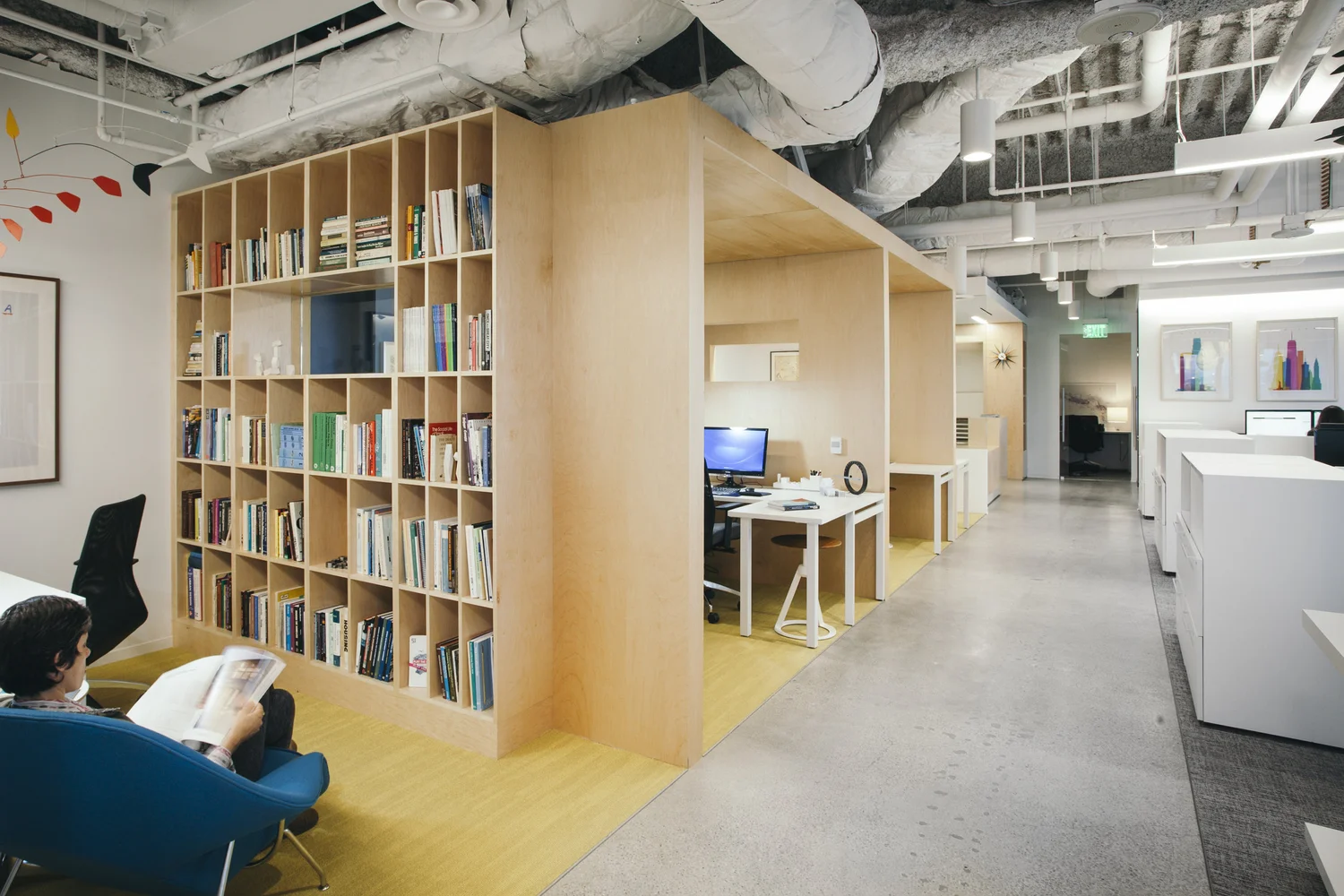 HR&A Offices, oficina abierta con módulo de madera y libreros integrados