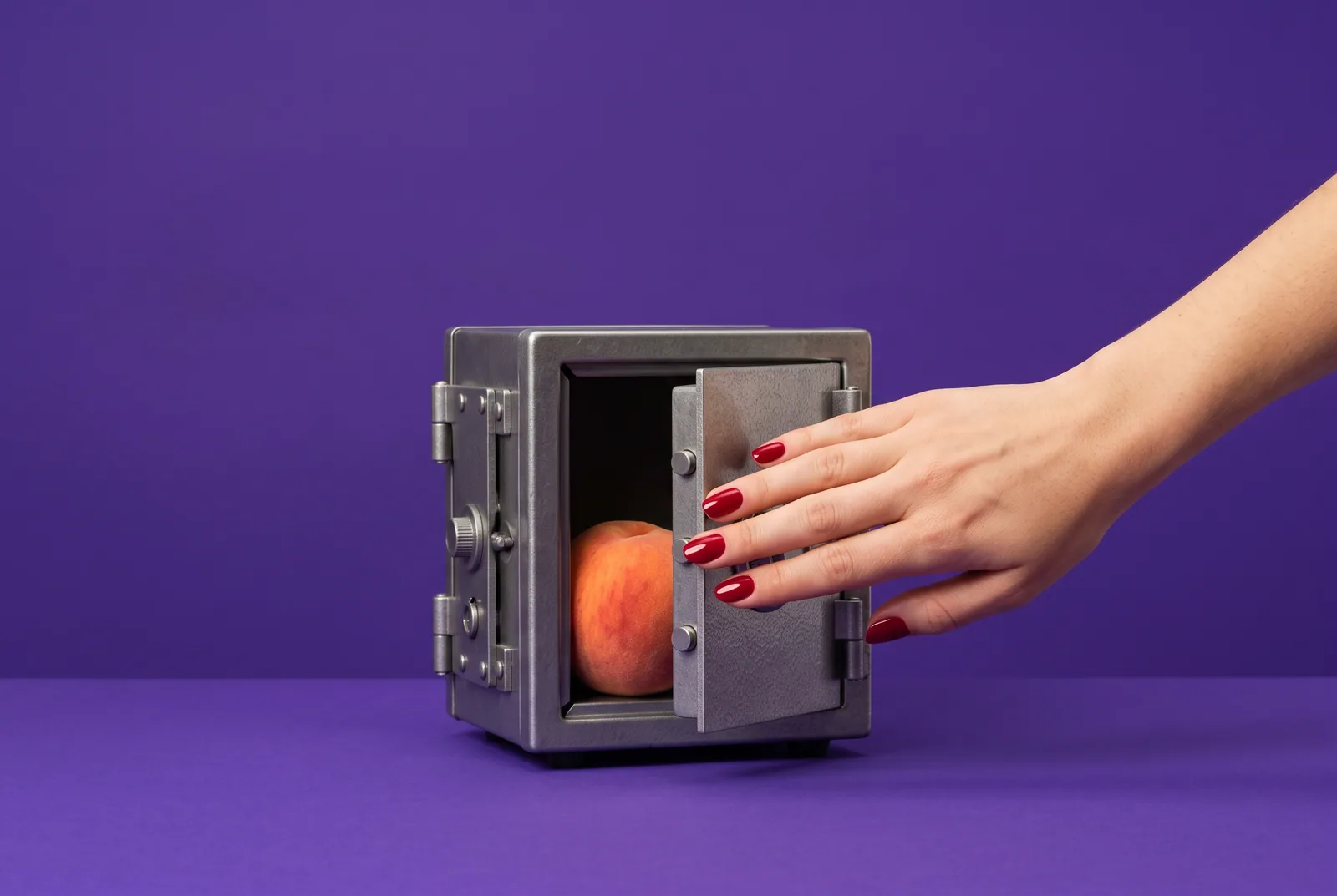 A hand closing a tiny steel safe with a peach inside, making a free porn blocker harder to bypass