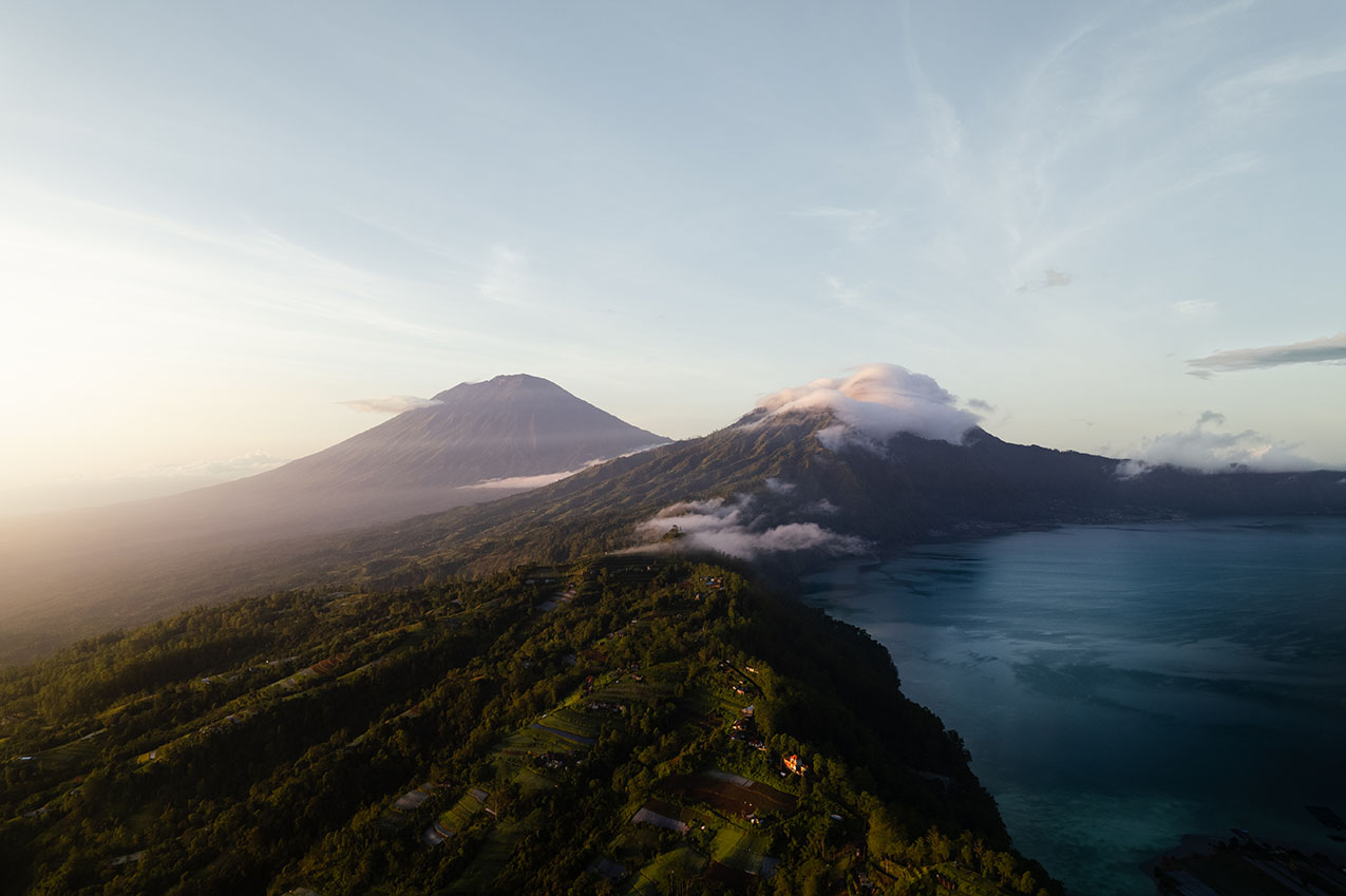 Sunrise drone shot of mountains and a lake with clouds in Bali, Indonesia.
