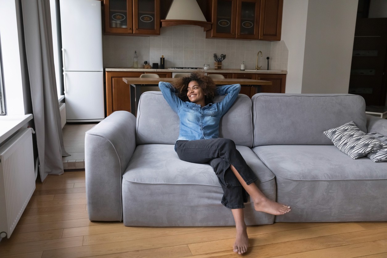 Women relaxing on her couch after installing a new heat pump in her home