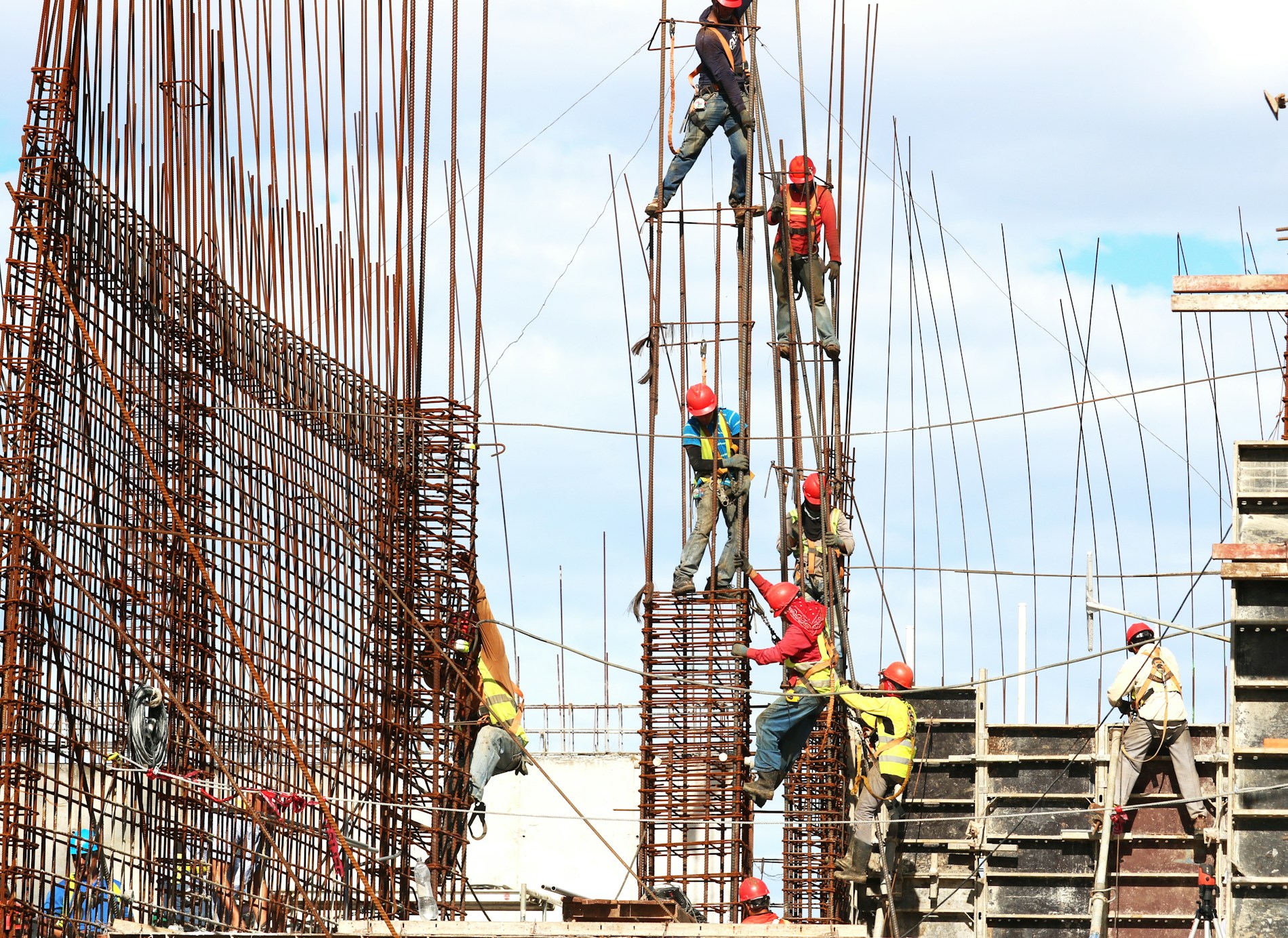 Workers building a concrete structure with rebar on an active site
