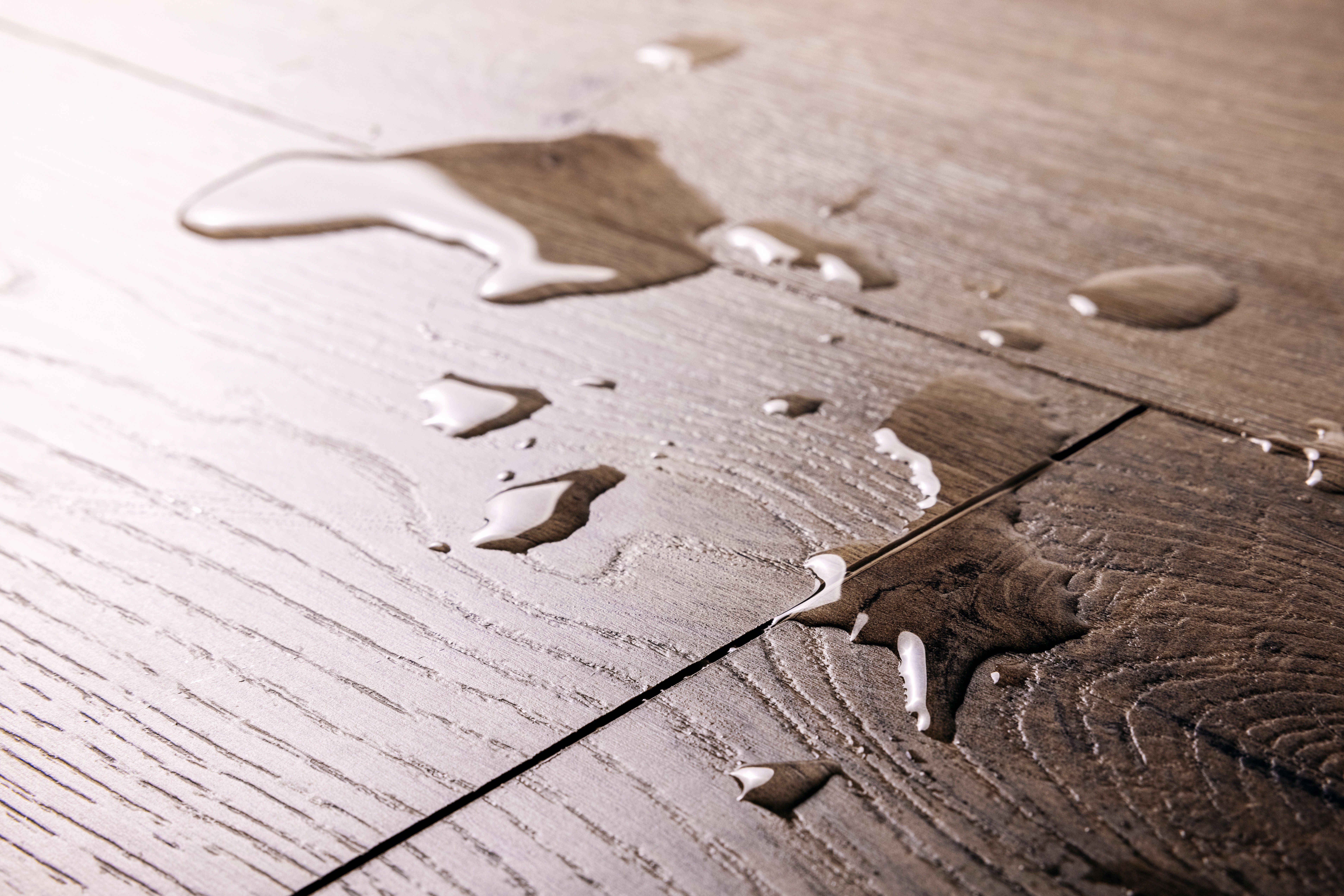 Installer scoring a luxury vinyl plank with a utility knife and straightedge