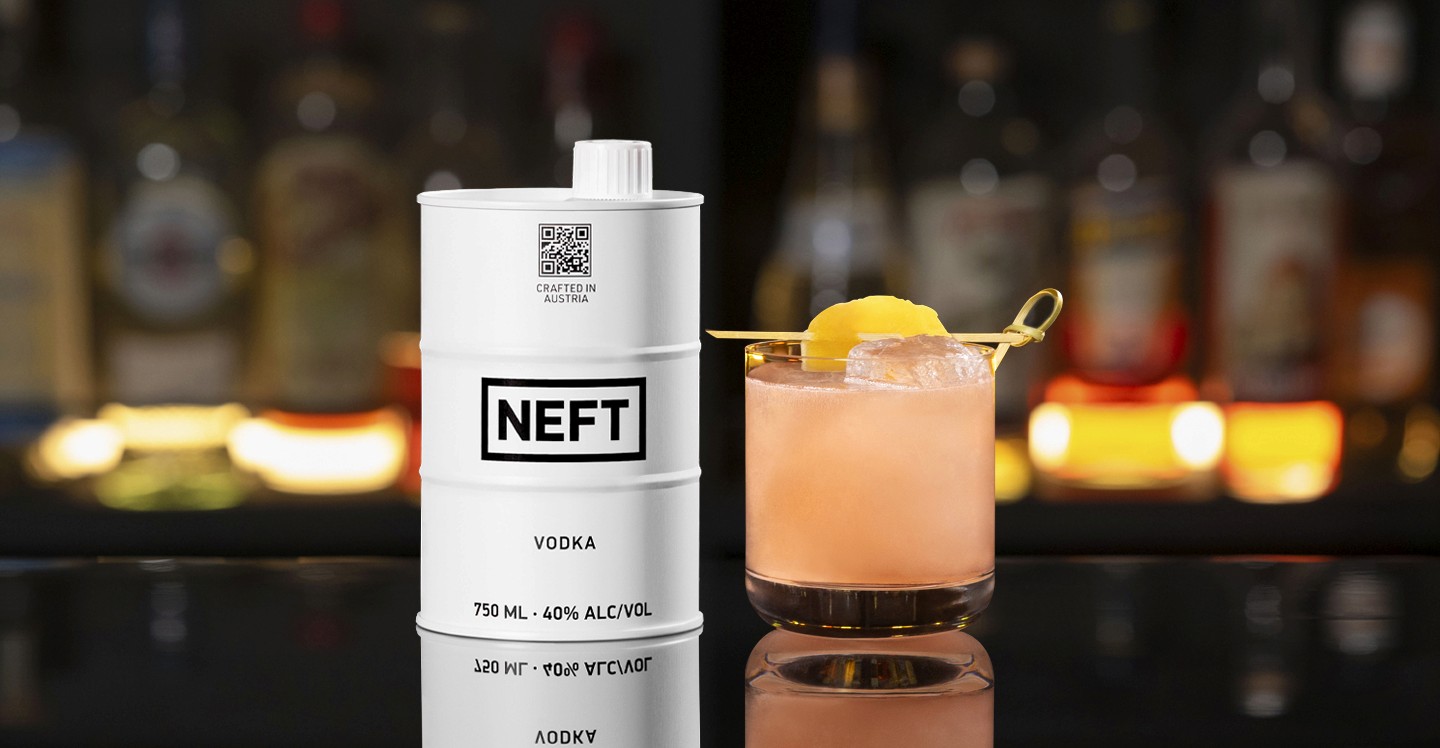 A NEFT Barrel and a glass of Tropical Peach on a bar counter.
