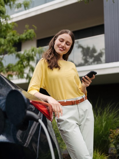 ragazza-appoggiata-ad-auto-elettrica-in-carica