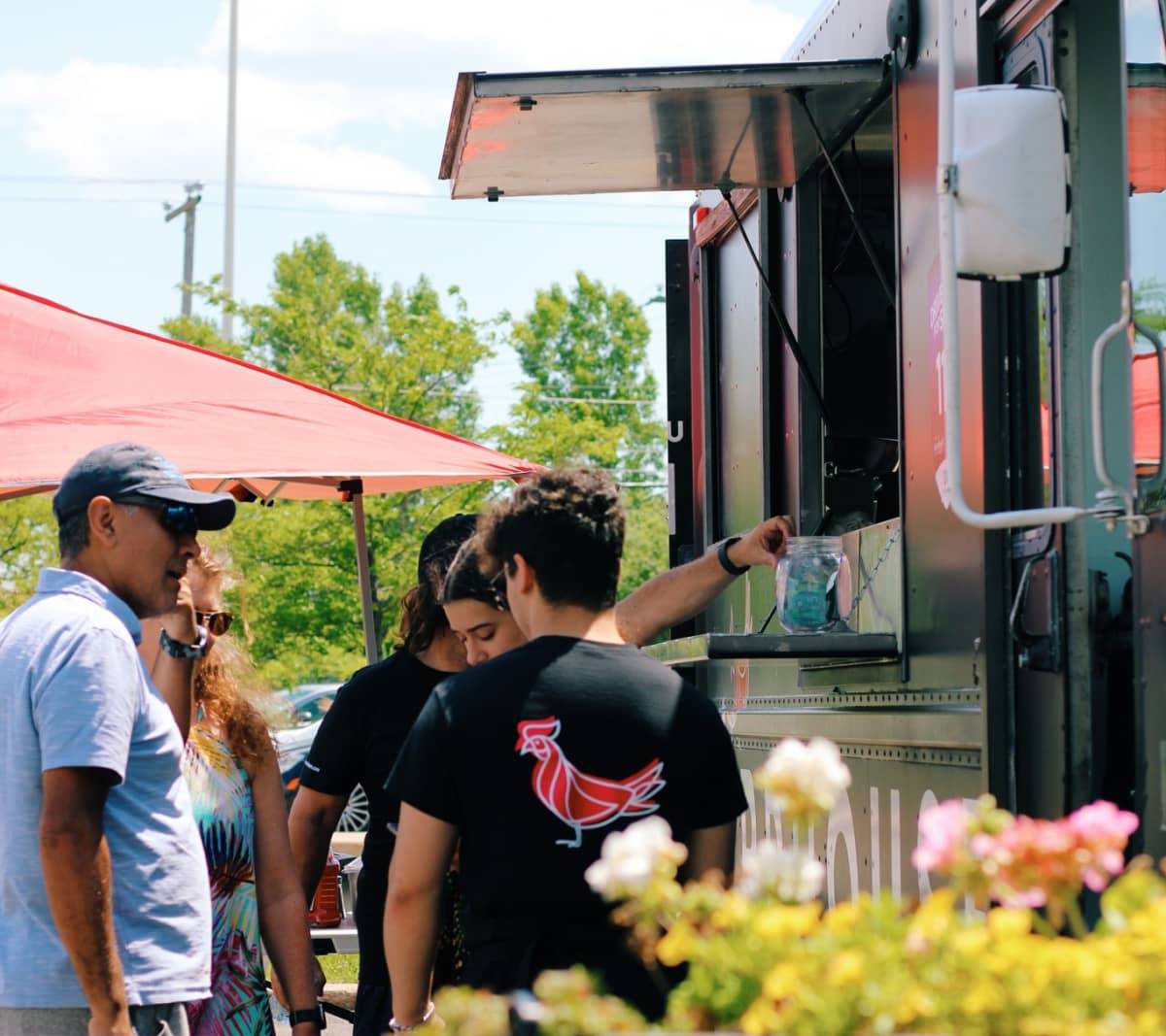 Clients passant des commandes à l'extérieur du food truck de Birdhouse
