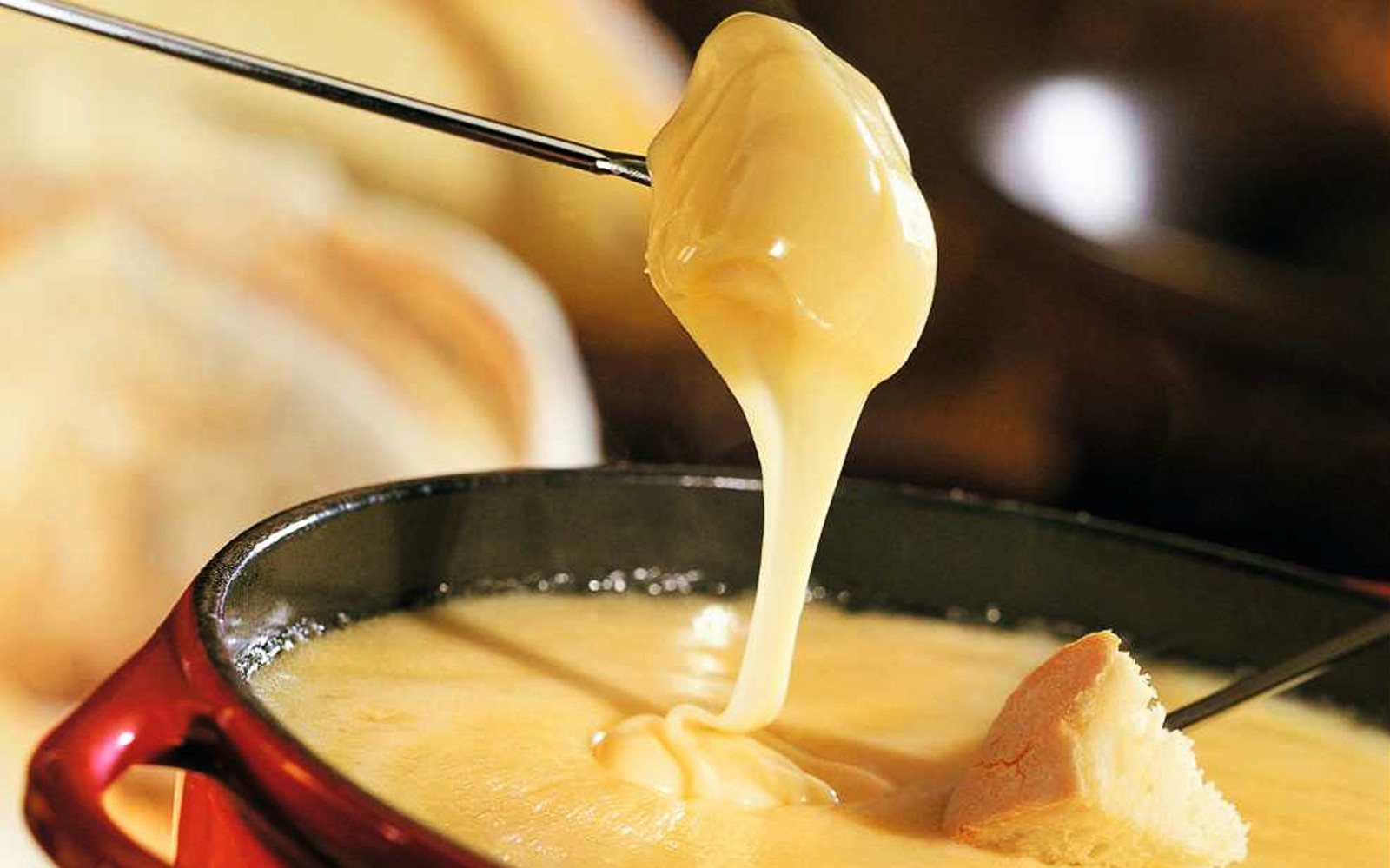 Cheese fondue with bread on skewer during Zürich evening tour.