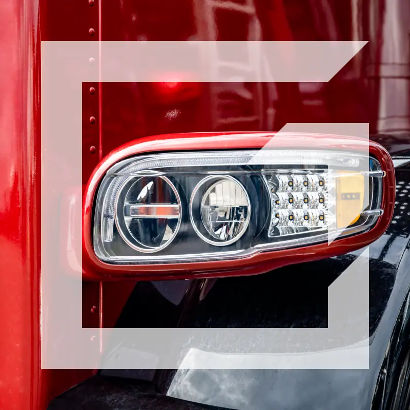 Close-up of a red semi-truck headlight — representing the drive, focus, and professionalism of the GIA Group, LLC team serving the trucking industry.