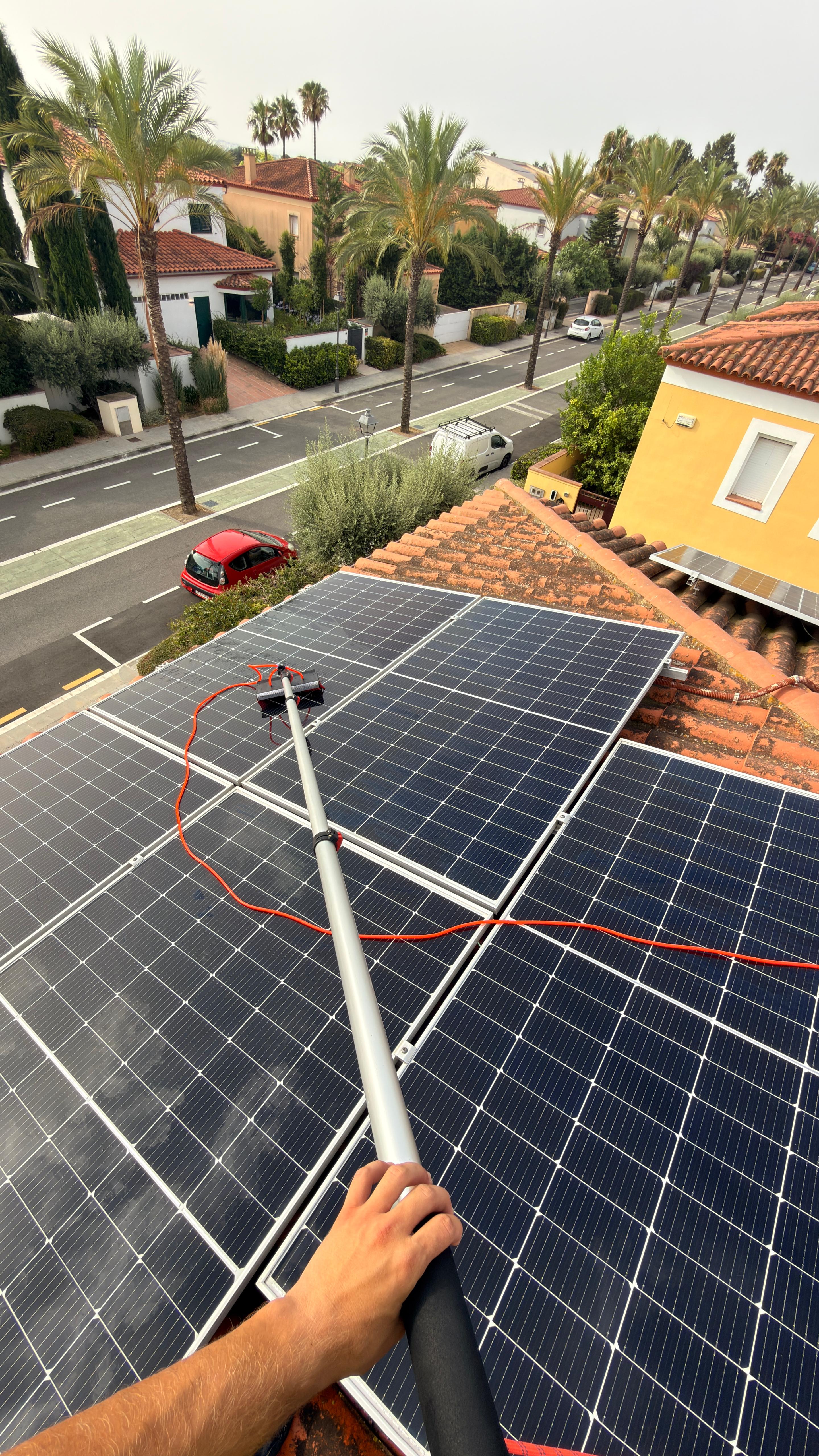 limpieza de paneles solares en cubierta residencial con pértiga de agua desionizada en Tarragona