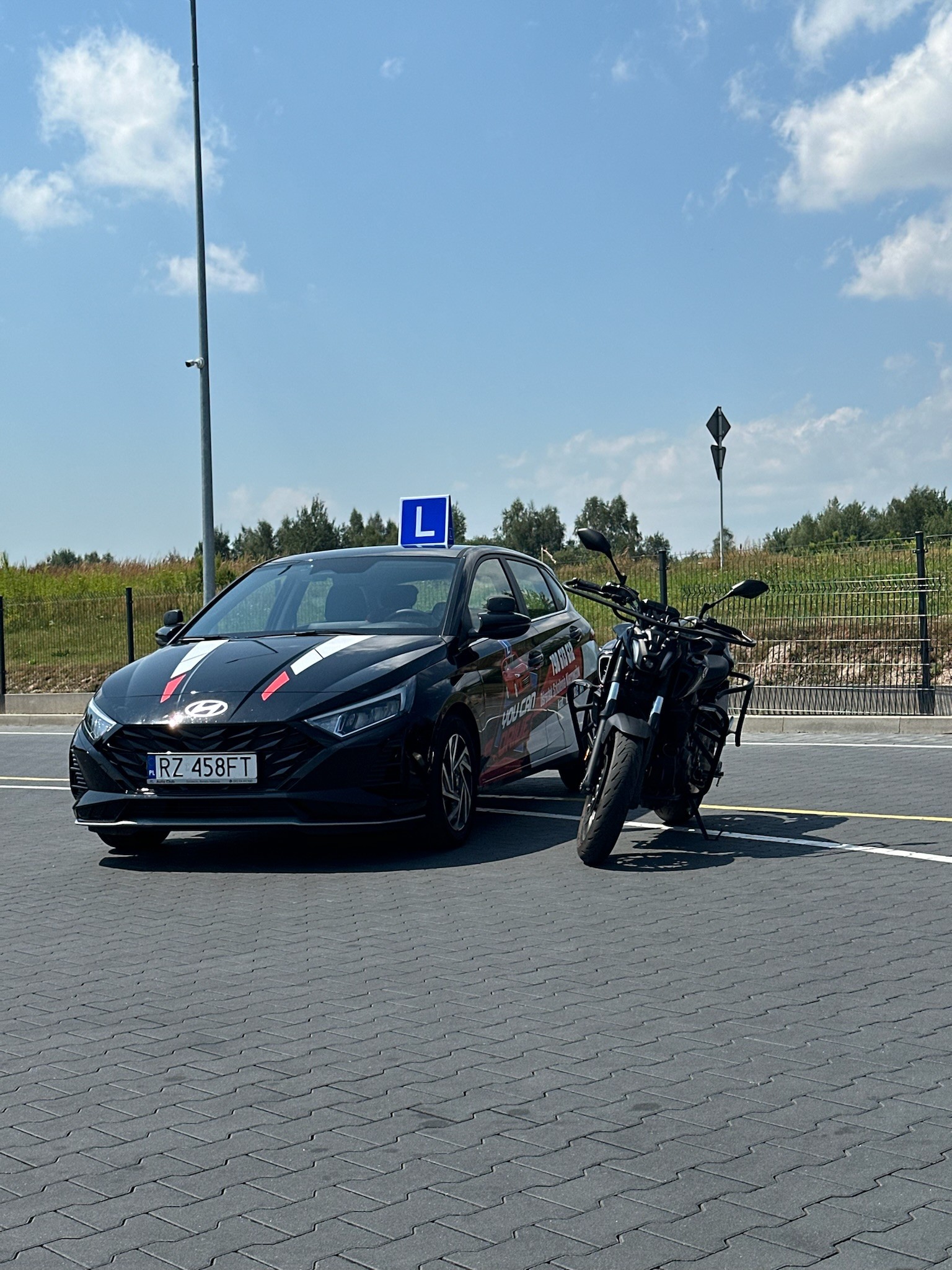 Samochód i motocykl w szkole nauki jazdy OSK You Can Drive w Rzeszowie na placu manewrowym.