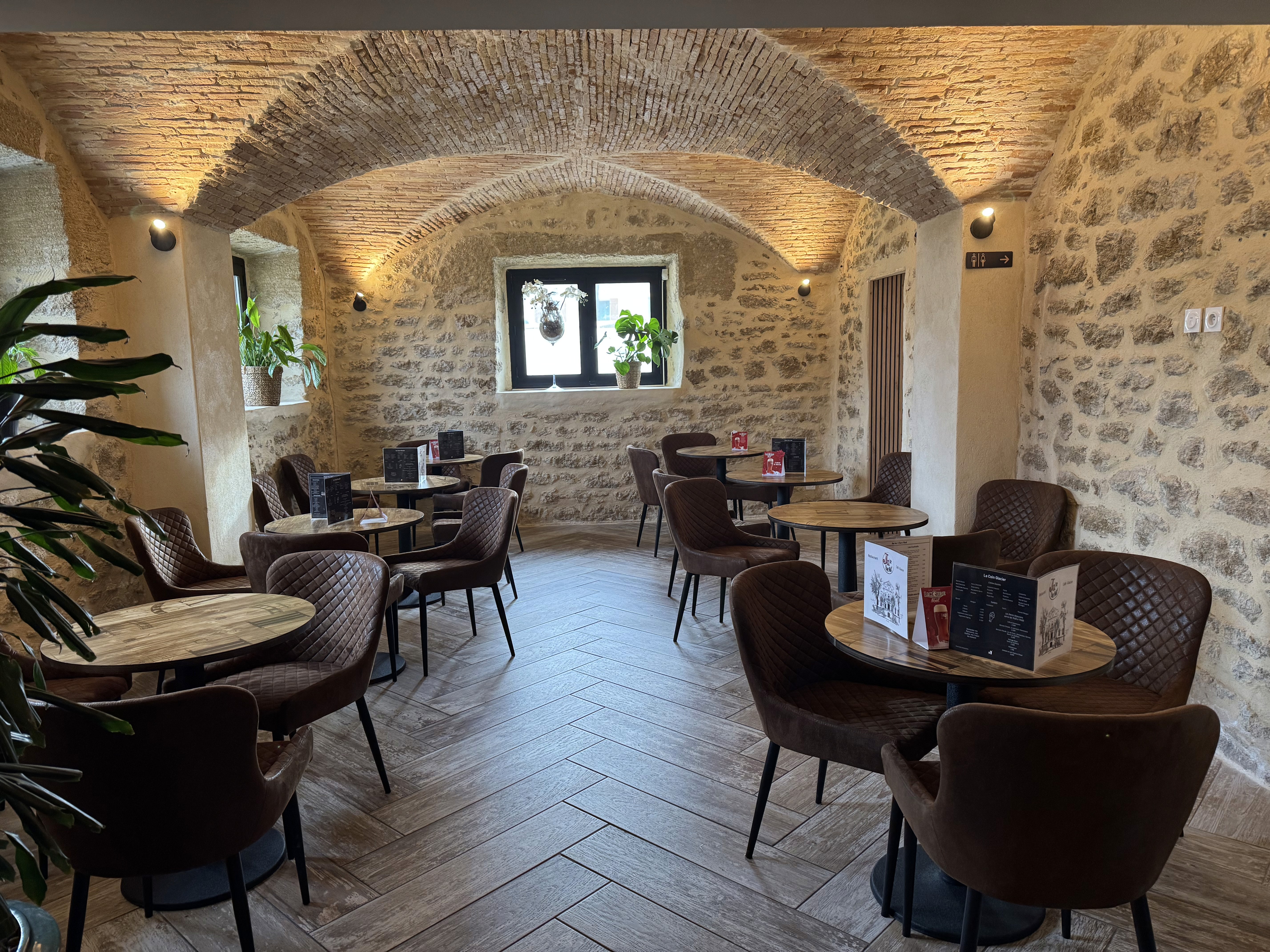 Intérieur d'un restaurant avec murs en pierre et mobilier design.