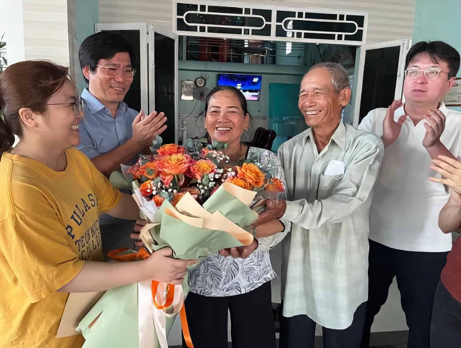 Ngày 12, tại nhà riêng ở huyện Điện Bàn, bà Nguyễn Thị Thanh (thứ ba từ trái sang) – người sống sót trong vụ thảm sát dân thường xảy ra ngày 12 tháng 2 năm 1968 tại hai ngôi làng Phong Nhị và Phong Nhất do quân đội Hàn Quốc ở Việt Nam gây ra, tỉnh Quảng Nam, miền Trung – nhận bó hoa chúc mừng thắng kiện sơ thẩm từ một người dân địa phương (ngoài cùng bên trái). Bên trái bà Thanh là luật sư Kim Nam-joo thuộc Hội Luật sư vì Xã hội Dân chủ (Minbyun), bên phải là ông Nguyễn Đức Trãi – nhân chứng vụ thảm sát đồng thời là chú ruột của bà Thanh, và ngoài cùng bên phải là luật sư Park Jin-seok của Minbyun. Hai luật sư này trong ngày đã đến thăm nhà bà Thanh để giải thích kết quả phán quyết sơ thẩm.</p>
Điện Bàn – phóng viên Heo Kyung-joo.