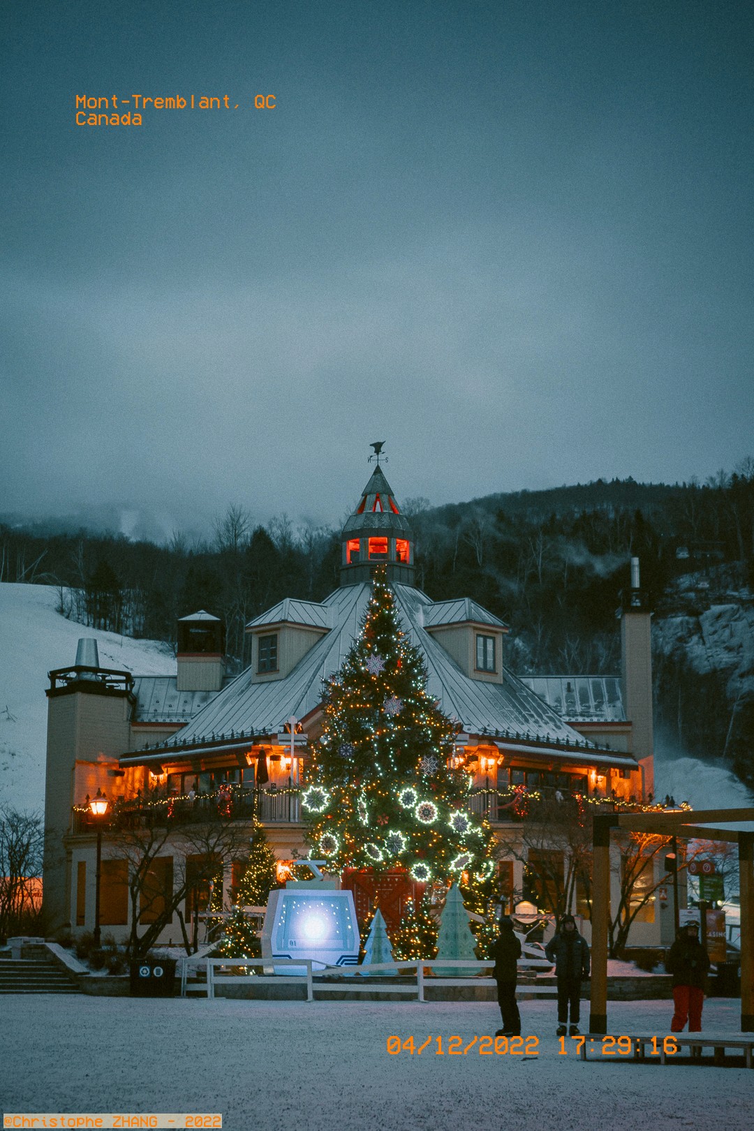 Arbre de Noël lumineux devant un bâtiment pittoresque à Mont-Tremblant en hiver.