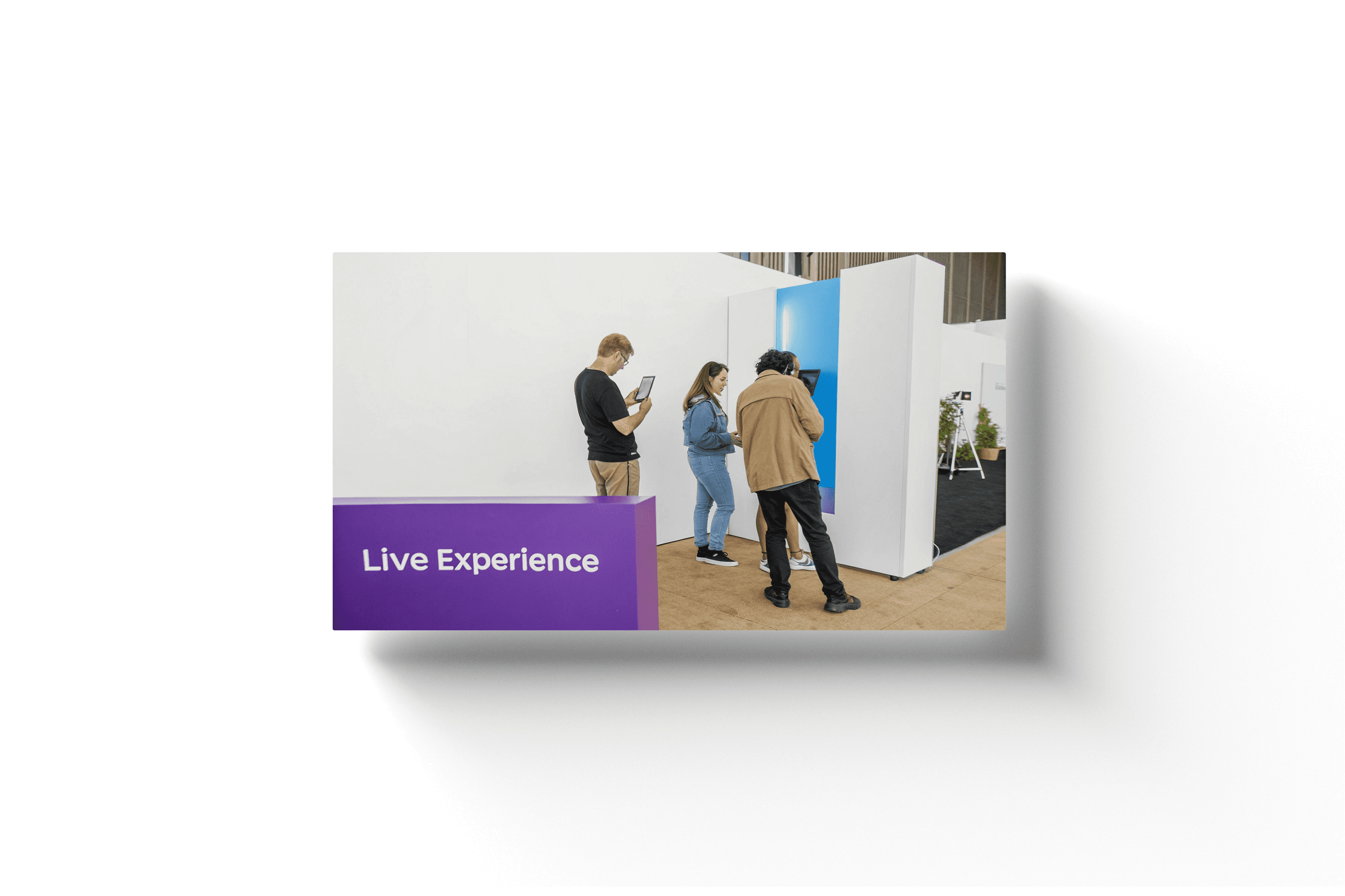 a group of people standing around a piece of art with the text 'live experiences' on a purple banner