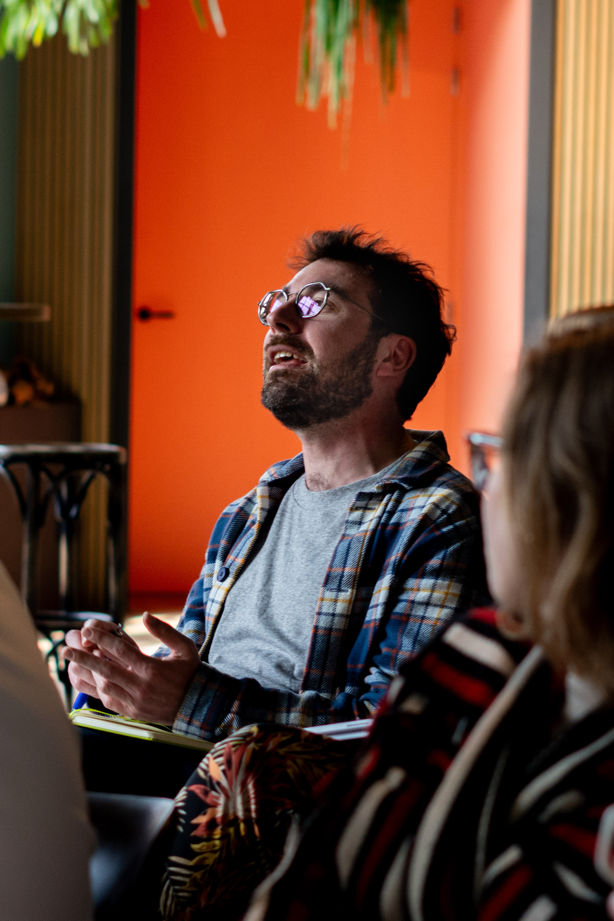 man sitting on chair wearing gray crew-neck long-sleeved shirt using Apple Magic Keyboard