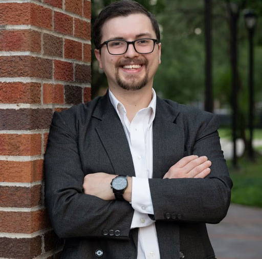 A photo of Isaiah Harris leaning against a brick pillar.