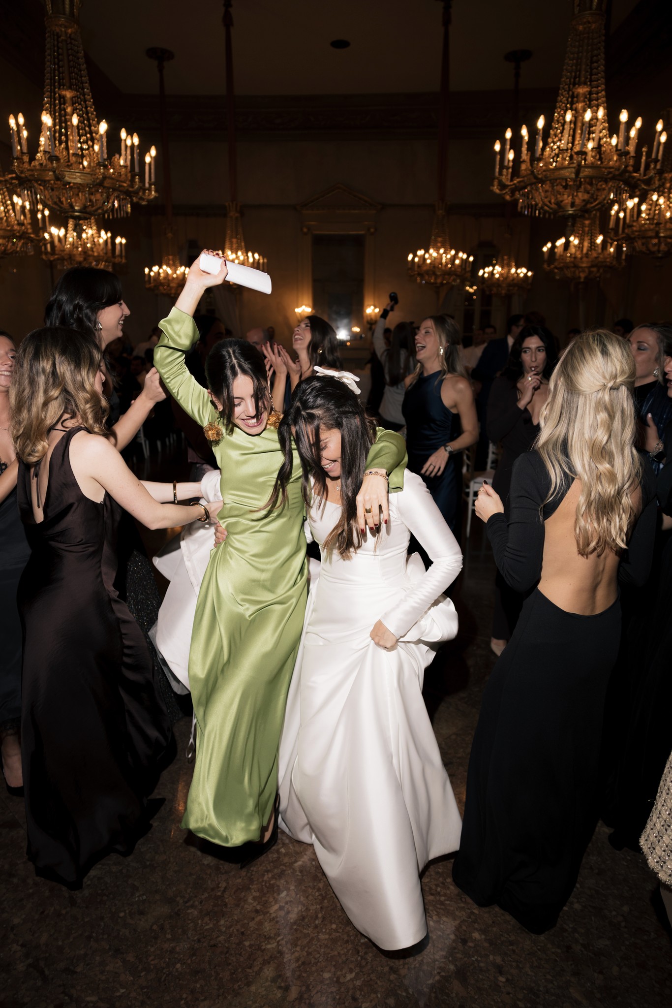 Sposa in abito bianco balla con ospiti in sala con lampadari, ricevimento matrimonio al Circolo di Lettura Parma