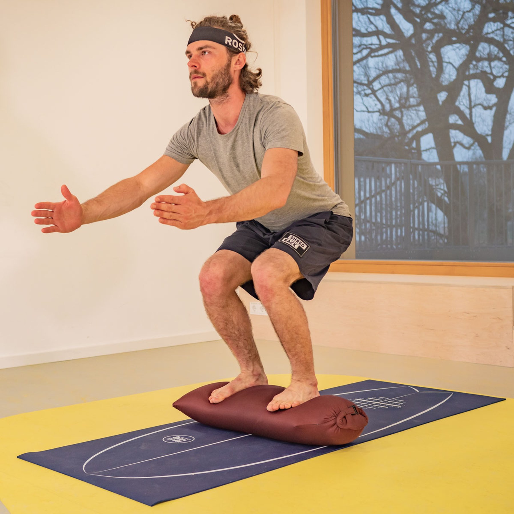 Squat standing on the BOLSTair: the unstable surface forces the body into constant balancing movements — proprioceptive training on the inflatable cushion Tobi Deckert developed himself